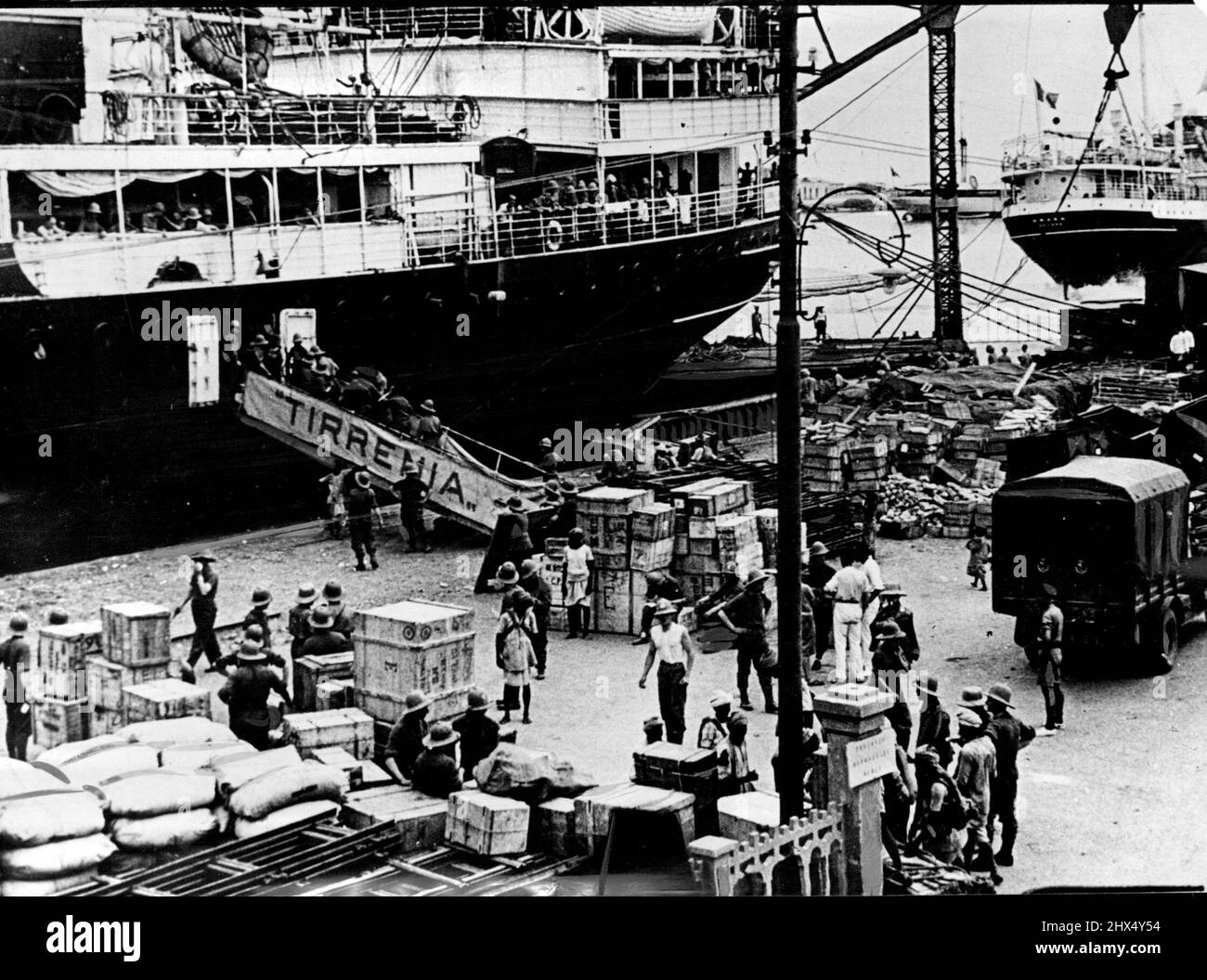 Italie préparation des fournitures d'Afrique de l'est qui se déversent dans le port fortifié la scène sur le quai de Massowah, en Érythrée - le port fortifié de l'Italie - montrant les piles de fournitures qui sont déchargées des navires. Des provisions, des armes à feu, des voitures et du matériel informatique se déversent maintenant dans le port italien de Massowah, en Érythrée, dans un courant constant alors que l'Italie jette de plus en plus de ses ressources dans l'approvisionnement et l'équipement des milliers sur des milliers de soldats qu'elle envoie couper là. 30 août 1935. (Photo par photo de presse associée). Banque D'Images