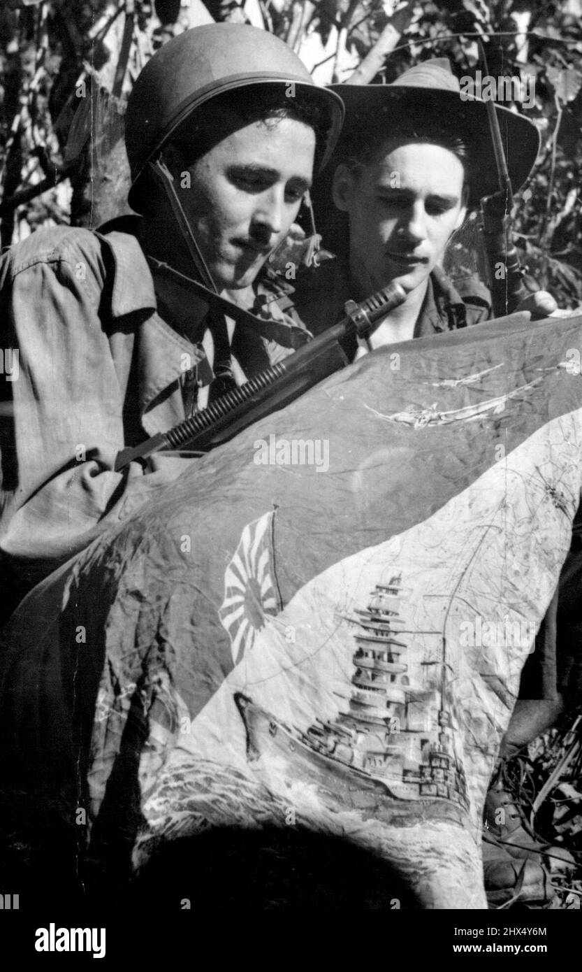 Capture alliée de Mubo. Le sergent Robert Clark de Los Angeles et le caporal Horrie Panye de Drummoyne, N.S.W., avec un pennant de Jap capturé pendant les combats à Nassau Bay. Le fant a été illustré avec un croquis représentant la marine et l'aviation de Jap en action. 5 août 1943. (Photo du ministère de l'information du Commonwealth d'Australie). Banque D'Images