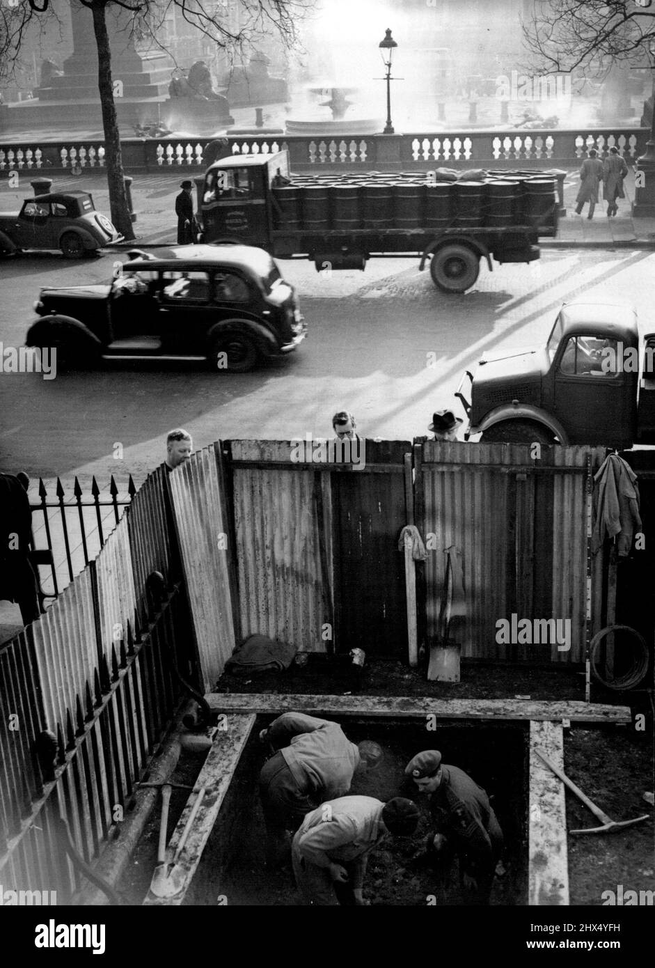 Une autre « exposition » pour la National Gallery - en regardant depuis l'avant de la National Gallery, Trafalgar Square, Londres à jour (mercredi) sur le trou qui est creusé dans le trou qui est creusé dans la pelouse dans une recherche d'une possible bombe non explosée. Têtes de déjeuner - des spectateurs d'une heure sont vus en train de faire le tour de la clôture qui entoure le site. Une douzaine d'ex-prisonniers de guerre allemands sous la supervision d'un sergent d'état-major de la Royal Engineering participent au creusement qui a commencé ce matin. Un trou sous lequel une bombe peut se trouver a été trouvé par les jardiniers travaillant sur la pelouse dernier Saturda Banque D'Images