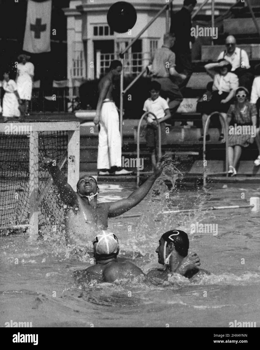 Olympiades - Water Polo - Italie Beats Australie : P. Buonocore, gardien de but italien de l'équipe olympique de polo d'eau, fait une économie lors de l'attaque par l'Australie dans leur match à la piscine en plein air, Finchley, Londres, aujourd'hui 30 juillet. L'attaquant australien (capuchon blanc) est Jack Ferguson. Le Defender italien (capot noir n° 2) est N. Bulgarelli. L'Italie a gagné 9-0. 30 juillet 1948. (Photo de l'Association olympique de photo). Banque D'Images