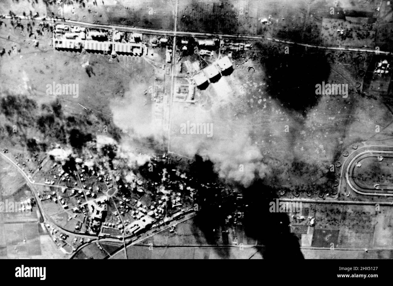 U.S. planes Blast German Airfield en Italie - la fumée et les incendies obscurcissent partiellement l'aérochamp de Ciampino tenu par l'Allemagne, près de Rome, comme B-26 Marauder bombardiers moyens de l'armée de l'air américaine de 12th larguer des centaines de bombes de fragmentation sur les avions ennemis et les installations à la base. 28 février 1944. Banque D'Images