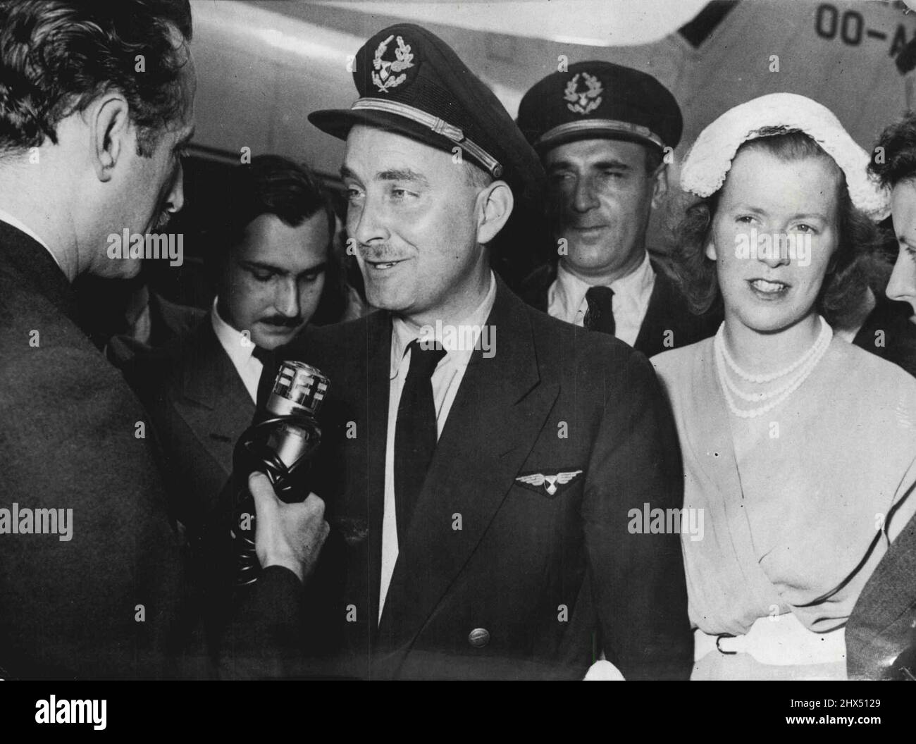 Attaqué avion Home -- Un avion de Sabena belge qui a été abattu jeudi par un avion de chasse MIG-15 près de la frontière entre les juges autrichiens, a été renvoyé à Bruxelles hier. Voici le deuxième pilote britannique, le premier officier Douglas Wilson, qui a débarqué l'avion, interviewé à son arrivée à Bruxelles. Un avion de la Sabena belge abattu par un avion de chasse M16-15 près de la frontière entre l'Autriche et le Yogoslav a été ramenté à Bruxelles l'autre jour. Ici deuxième pilote britannique. Le premier officier Douglas Wilson, qui a débarqué l'avion, est interviewé. 7 juin 1954. Banque D'Images