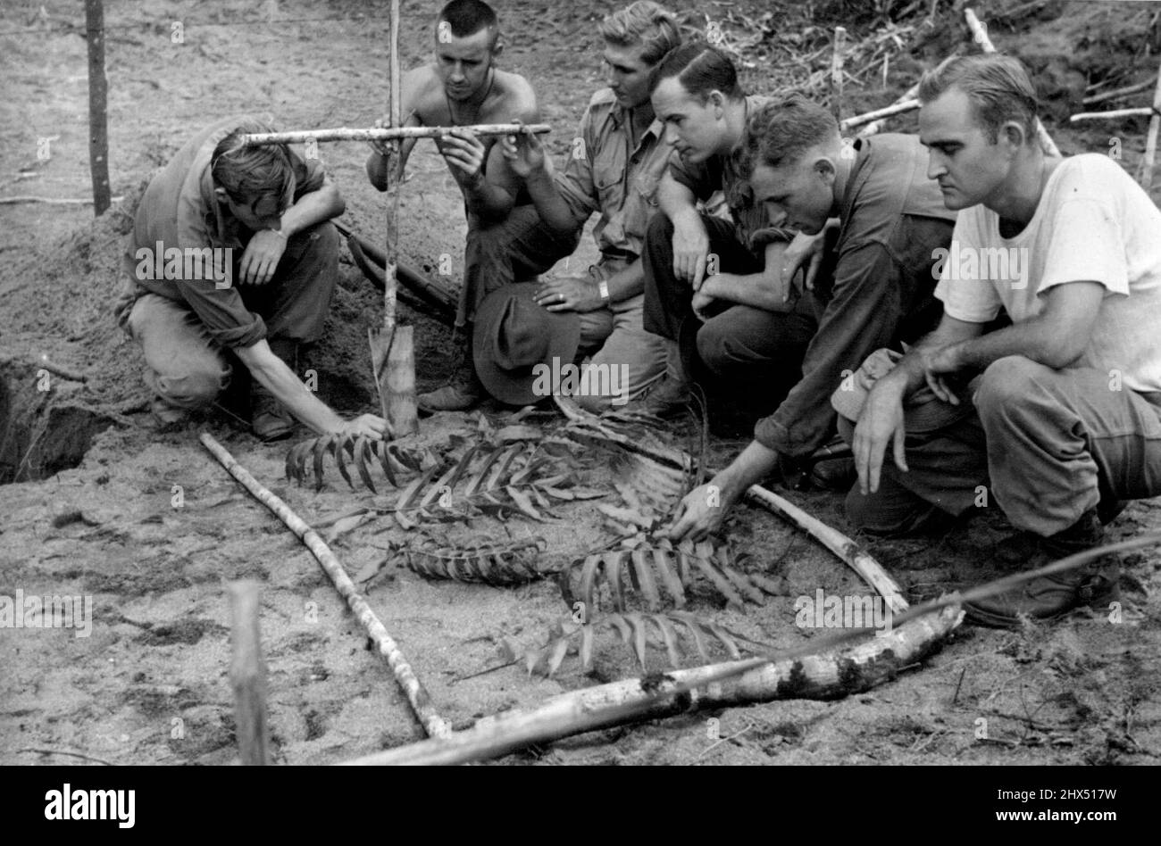 Capture alliée de Mubo. Des soldats australiens et américains marquant la tombe d'un pilote de la R.A.A.F. tué lors de l'avance des alliés sur Mubo. 30 août 1943. (Photo du Département de l'information du Commonwealth d'Australie). Banque D'Images