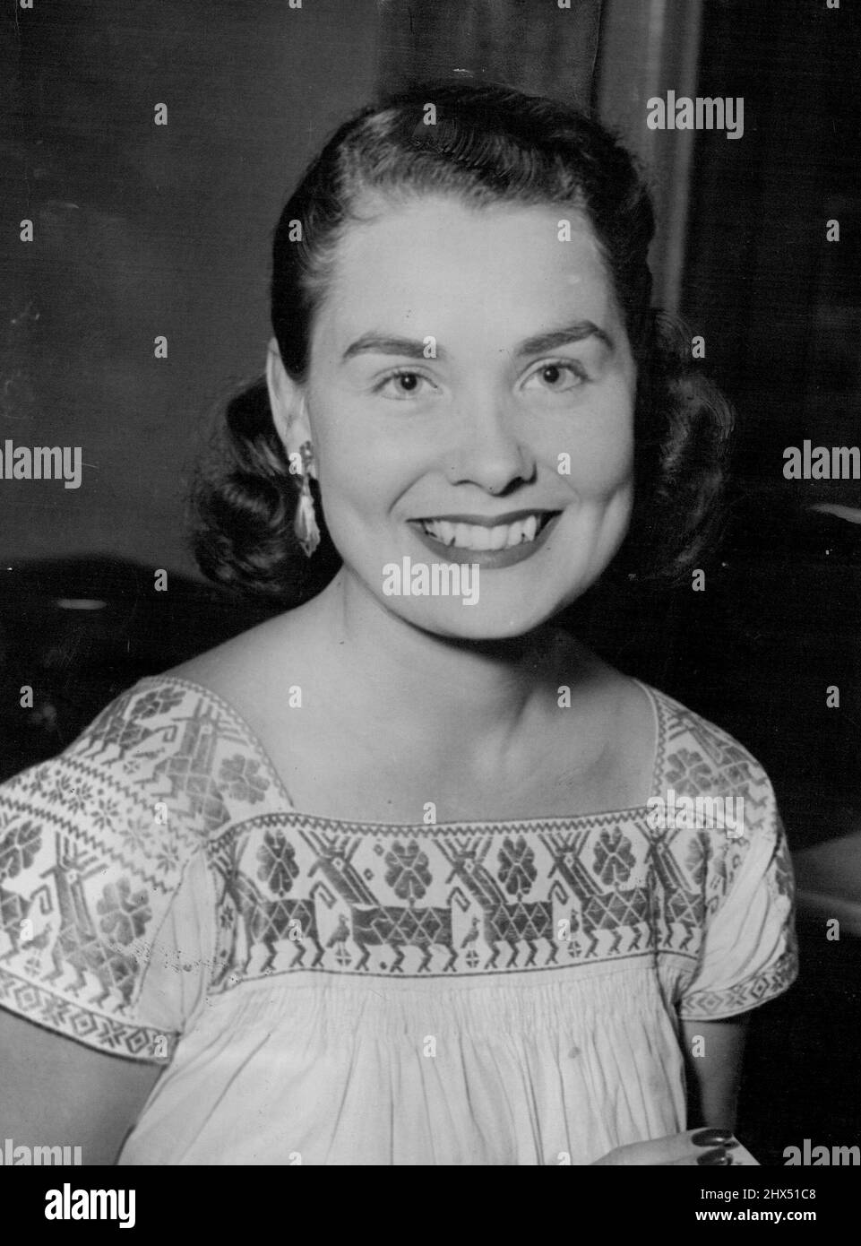 Mme Vic Seixas, épouse du capitaine de la coupe Davis des États-Unis, a apporté de la couleur aux courts de tennis d'Australie. Tout en regardant son mari s'entraîner pour le concours contre l'Australie, elle portait cette grenouille en coton tissé à la main de style paysan qu'elle a achetée à Mexico. La jupe est tissée en vert jade avec une trame blanche, tandis que le haut de la blouse blanche inverse les couleurs - elle est brodée gaious en vert jade. 26 décembre 1952. (Photo par les nouvelles et le courrier). Banque D'Images