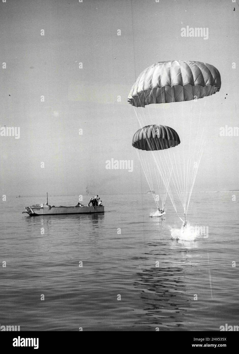 Plongée extra-haute - avec une éclaboussure colossale, Royal Marines dans un kit de natation sous-marin, s'est plongé dans la mer d'un R.A.F. Hastings transporte des avions au cours d'un exercice de routine au large de Southsea, Hampshire, aujourd'hui (mardi). Un embarcation en attente. 31 août 1954. Banque D'Images