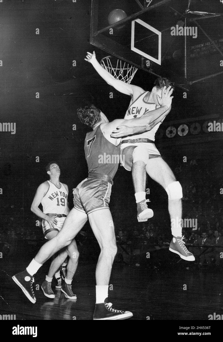 Le chef « Palm in the face » -- John Palmer (à droite), New York Kniccurboker en avant, prend un palmier dans le visage car il fait une tentative infructueuse de bloquer Stan Miasek (7), Chicago Stag Reserve dans le deuxième quart de match à Madison Square Garden, New York, décembre 25. Miasek a lâché un but de terrain sur le jeu (balle sur le panier en haut à droite au centre.) Dans le fond gauche se trouve Lee Knorek (19), Knickerboker's Center. Le basket-ball haut de gamme vous offre de nombreuses possibilités. Ici, un joueur de New York obtient le pire d'un échange avec un Chicago Stag avant. 04 mars 1953. (Photo par photo AP). Banque D'Images