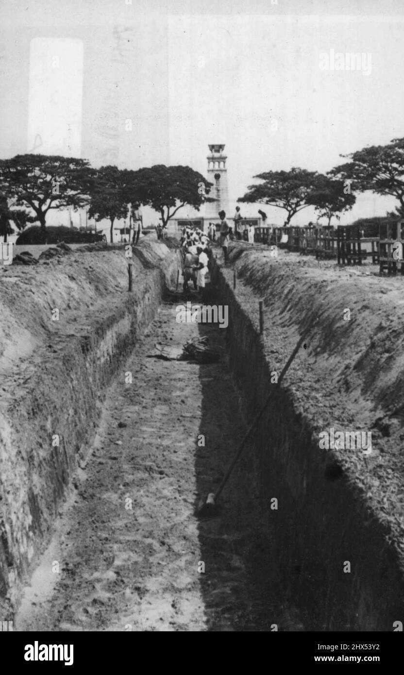 Singapour digue - les Singapouriens se débaissent de leurs défenses dans leur capitale. Cette lixiviation, le couvre-feu, ainsi que l'évacuation de la rive nord de l'île de Singapour figurent parmi les nombreuses mesures préparatoires prises pour protéger Singapour. 30 janvier 1942. (Photo par photo de presse associée). Banque D'Images