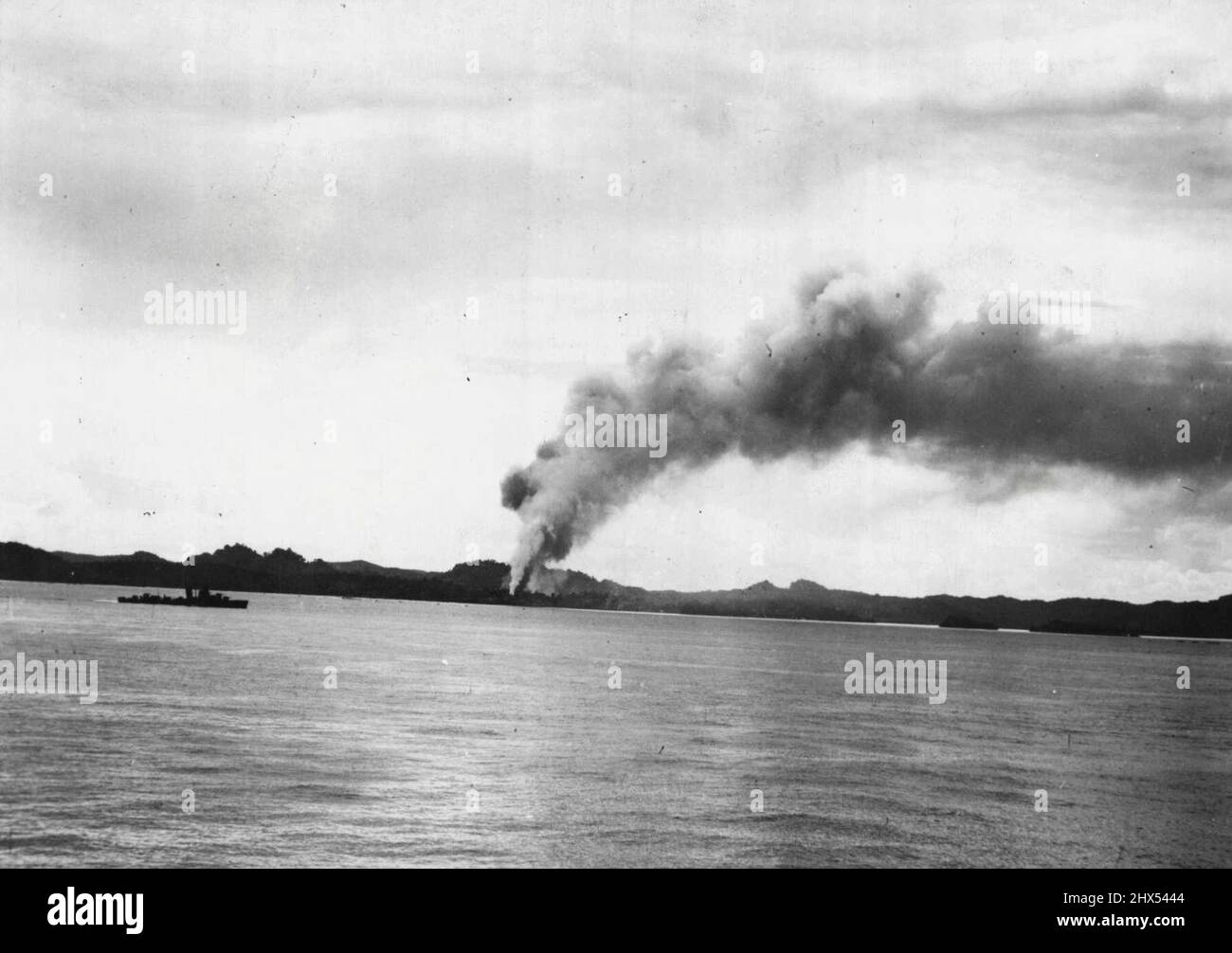 La flotte américaine repulse l'attaque de Jap à Solomons -- sept semaines de bataille incessante depuis que la flotte du Pacifique des États-Unis a livré son coup initial dans les îles Salomon trouve l'ennemi toujours en train de tenter une contre-attaque réussie. Plusieurs d’entre eux ont déjà tenté de revenir en arrière. Les phases d'un contre-assaut japonais sont vues dans cette série de photographies. Un pilier de ventilateurs de fumée dehors dans le ciel après une bombe américaine frappé sur les installations japonaises dans les Solomons. Les JAP ont été pilotés de cette île. Au premier plan se trouve un destroyer américain. 30 novembre 1942. Banque D'Images