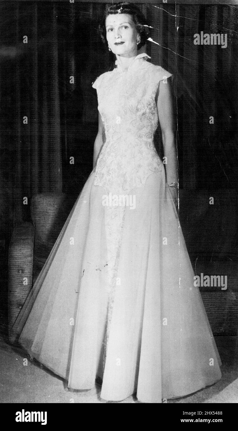 Affiche la robe inaugurale -- Mme Richard Nixon, épouse du vice-président élu, pose à la maison aujourd'hui dans la robe qu'elle portera au bal inaugural mardi soir prochain. La jupe est en filet bleu-vert doux. Le corsage ajusté de brocart a de petites fleurs à motifs bordés de perles de semence, centré avec des strass, et la tige avec des perles de bugle de cristal. La robe a un col haut, debout. 14 janvier 1953. (Photo par AP Wirephoto). Banque D'Images