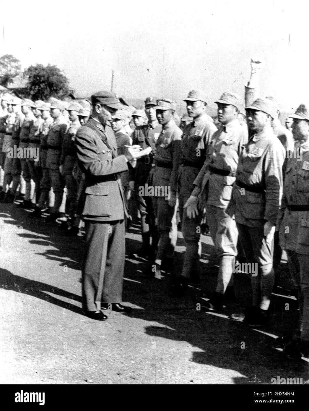 Formation en temps de guerre pour les travailleurs du gouvernement chinois. Appel nominal du chef de la nation, le généralissimo Chiang Kai-Shek. Une fois par semaine, le Generalissimo donne des conférences aux élèves de l'école de formation militaire centrale. Le jour où il donne des conférences, il prend lui-même l'appel, demande aux étudiants de courtes biographies d'eux-mêmes, et prend des notes sur chacun d'eux. Les étudiants répondent à l'appel en saluant le Kuomintang. 14 février 1955. (Photo de Paul Guillemette, film de Chine). Banque D'Images