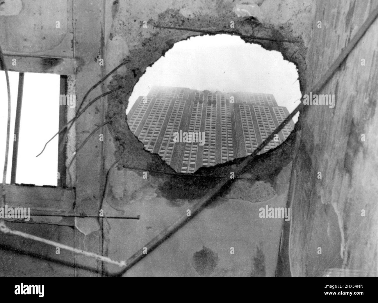 Où une partie de l'avion s'est écrasé -- cette vue étrange a été prise par le trou dans le toit de Penthouse sur 33rd rue, New York, juillet 28, en face de la rue de l'Empire State Building -- Un toit par lequel une partie de l'avion s'est écrasé est tombé et a mis Penthouse à l'abri. 28 juillet 1945. (Photo par photo de presse associée). Banque D'Images