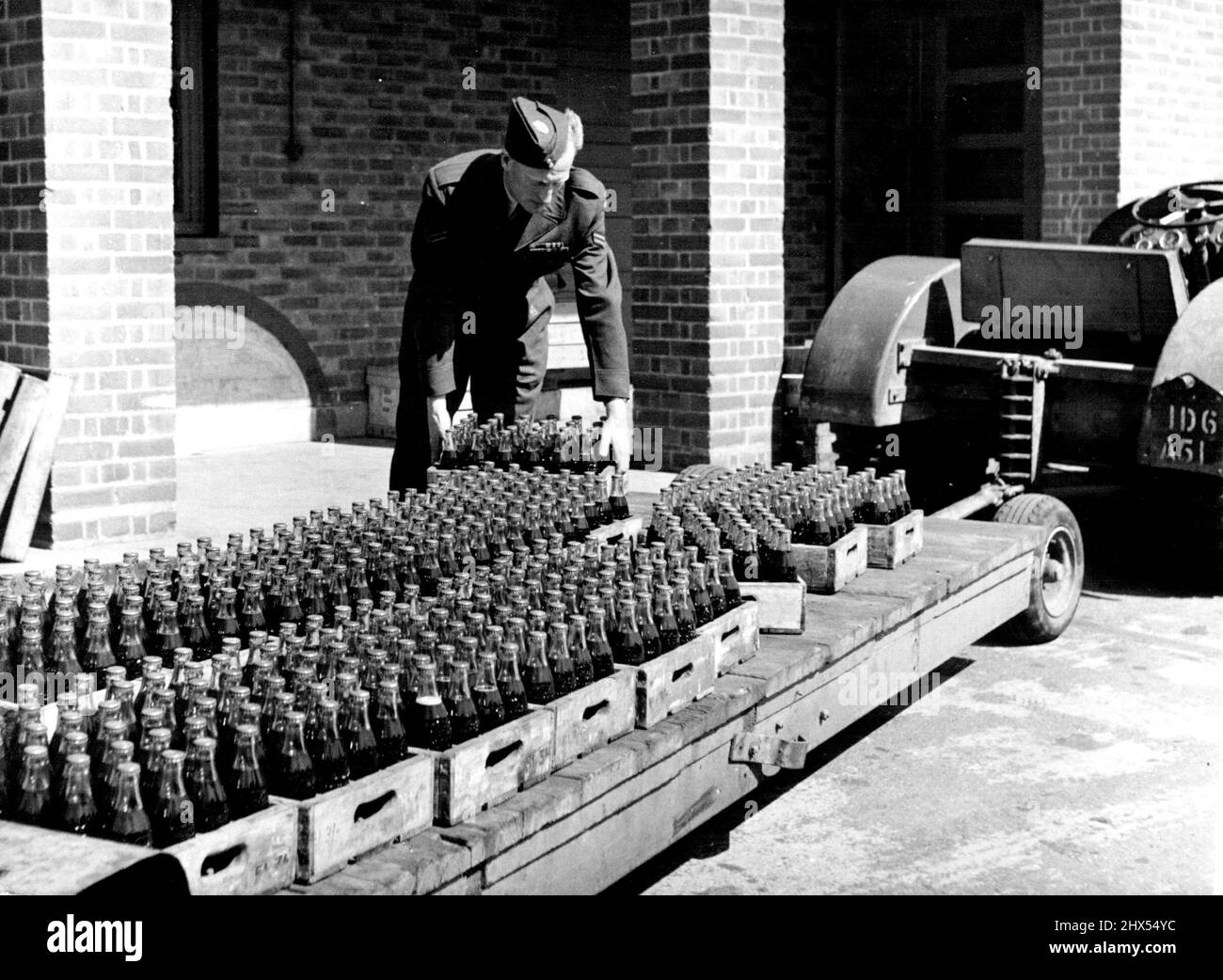 Little Canada -- la Royal Canadian Air Force en Angleterre. L'ARC en Angleterre - l'uniforme est plutôt comme la R.A.F., ainsi que le chariot à bombe -- mais la charge de bouteilles de coke montre qu'il est trans-Atlantique. Vu à N. Luffenham. Rutland, Angleterre. 1 juin 1952. (Photo du Bureau central d'information) Banque D'Images