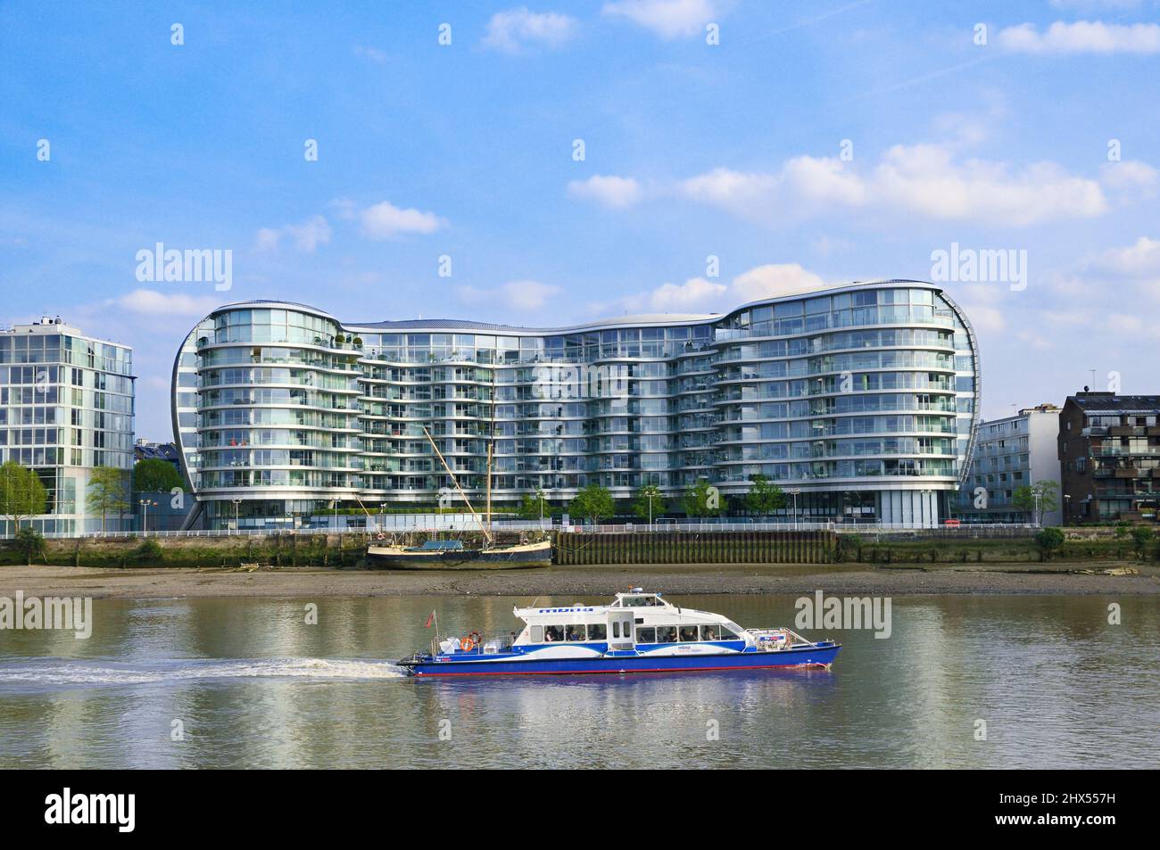 Un bateau-bateau sur la Tamise traverse le bâtiment Albion Riverside et traverse la Tamise à Battersea, Londres, Angleterre, Royaume-Uni. Architecte : favoriser et partenaires Banque D'Images