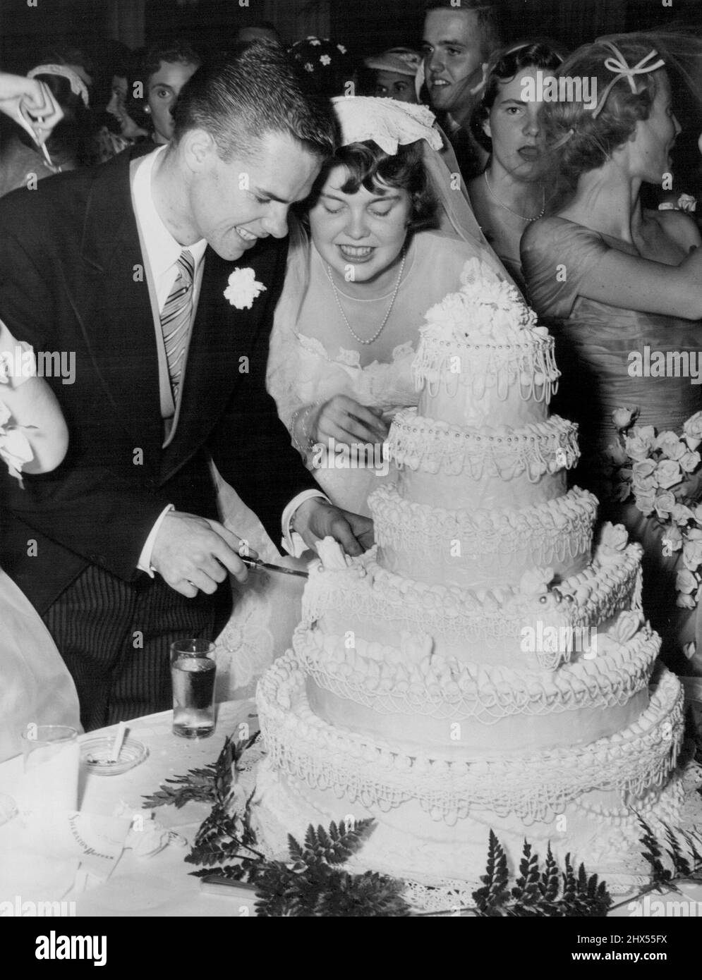 Spencer-Lynch Wedding -- Peter Spencer aide sa femme à couper le gâteau à la réception à l'hôtel Sheraton Park qui a suivi leur mariage à Christ Episcopal Church, Georgetown, Washington DC. Plus de 400 invités ont assisté à la réception. 02 juillet 1954. (Photo par Reni photos). Banque D'Images