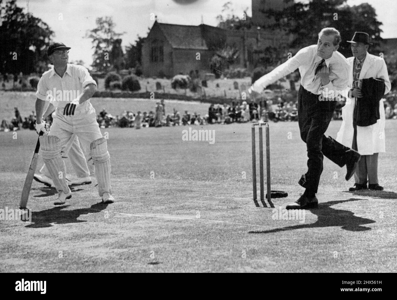 Le bal d'ouverture ouvre un terrain de jeu -- le Duc d'Édimbourg a ouvert un nouveau terrain de loisirs à Combe, Oxon, en faisant du bowling les premières balles d'ouverture lors d'un match de cricket joué entre un comté représentatif onze et l'équipe de Combe Village. La National Playing Fields Association, dont le duc est président, a largement contribué au coût du terrain. De l'expression sur le visage de l'homme de chauves-souris d'ouverture et son impatiente sera en direction des quartiers limites - le duc d'Édimbourg bowling la première des deux balles d'ouverture à Combe à jour. 19 juillet 1949. Banque D'Images
