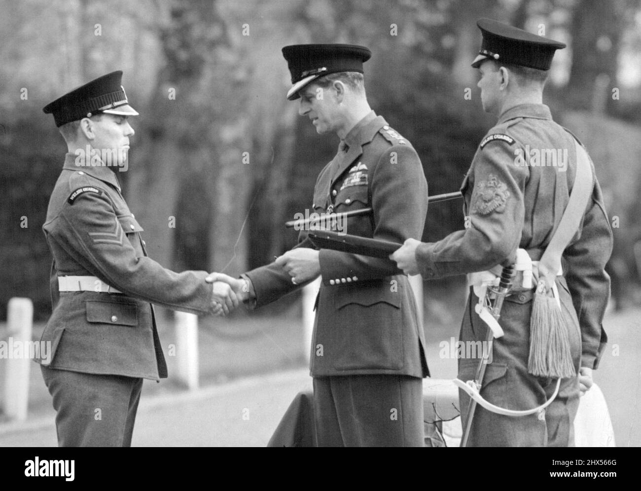 Une occasion royale pour les 'Taffys' -- le maréchal H.R.H. le duc d'Édimbourg a vu présenter une longue médaille de service et de bonne conduite au CPL. W. Hilton des Gallois Guards à Caterham Barracks aujourd'hui. H.R.H. le duc d'Édimbourg, colonel des gardes gallois, a rendu aujourd'hui visite au dépôt des gardes de Caterham. Après inspection no 8 Compagnie les gardes gallois, son altesse Royale a présenté un certain nombre de médailles. 04 novembre 1954. (Photo de Fox photos). Banque D'Images