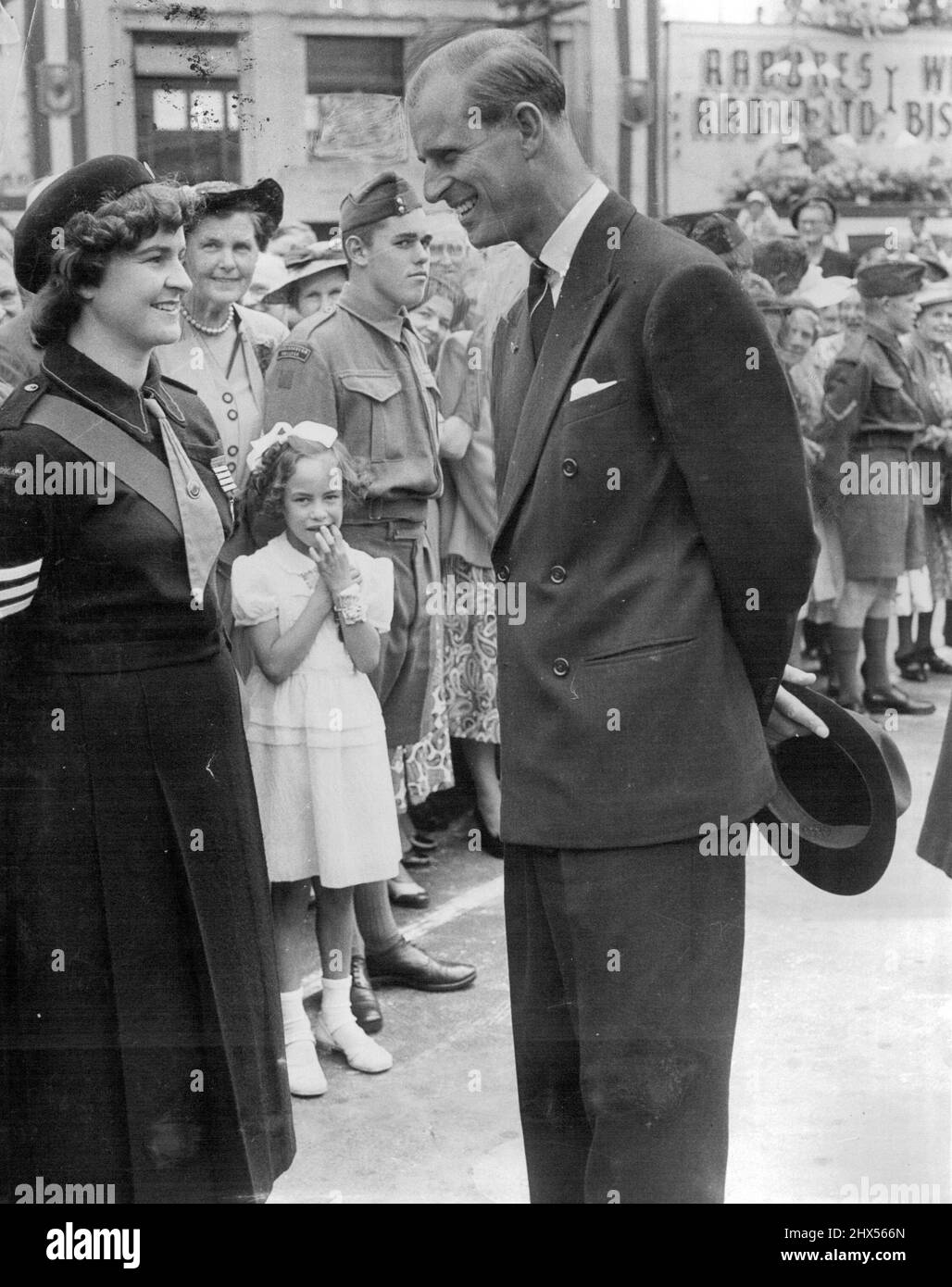 Duc d'Édimbourg discutant avec Judith Smart, membre de la Brigade de la vie des filles, à Blenheim, en Nouvelle-Zélande, tandis qu'une petite fille et un soldat regardent. La photo a été prise lors d'une réception lors de la visite de la fête royale à Blenheim. 02 mars 1954. Banque D'Images