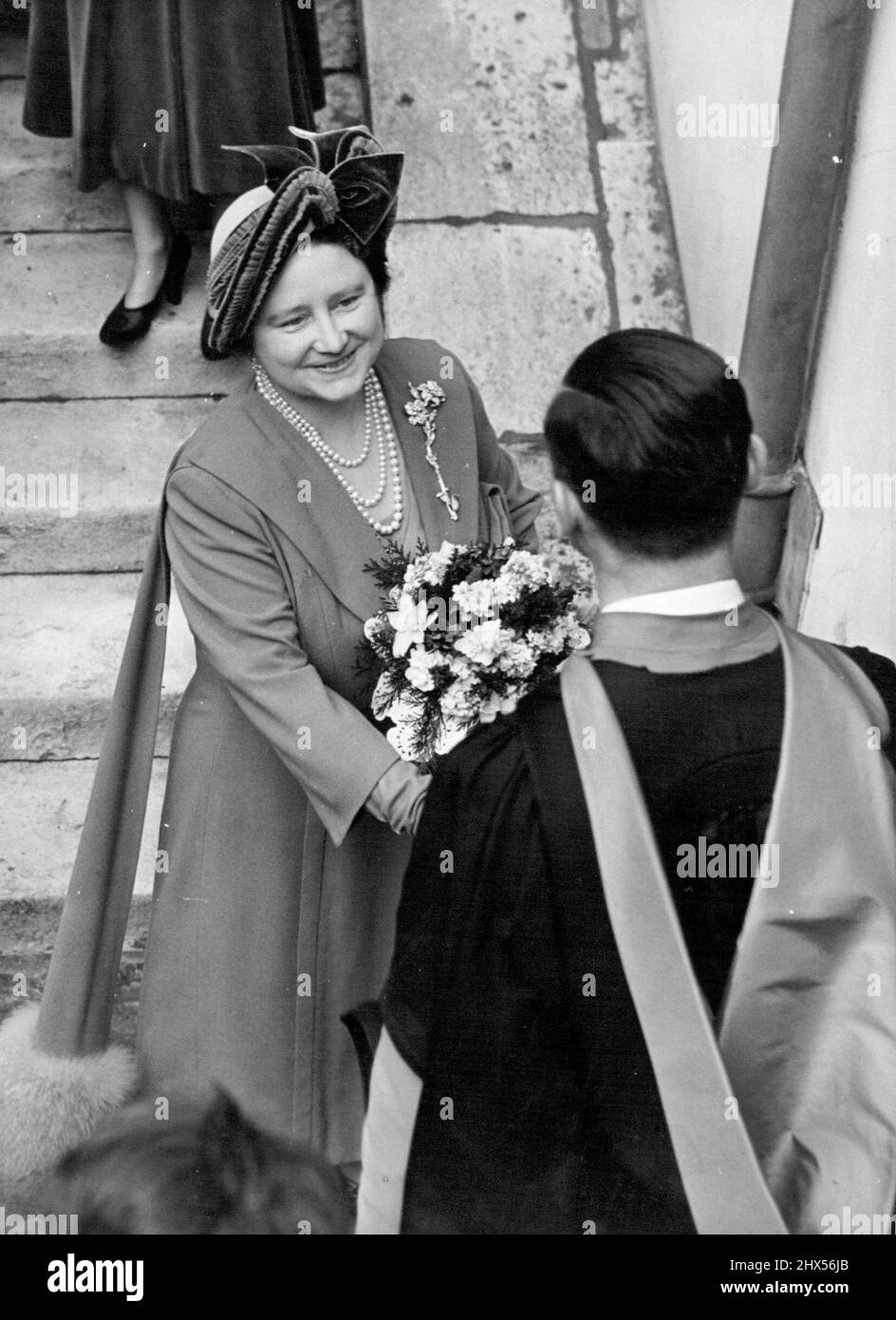 Le roi distribue l'argent de Royal Maundy Westminster -- la Reine discute avec l'un des maîtres de l'école de Westminster après la cérémonie d'aujourd'hui. H.M. le Roi a entrepris son premier engagement public depuis son récent refroidissement, aujourd'hui quand il a distribué les armoiries royales Maundy de l'abbaye de Westminster. La coutume décresse que l'argent de Maundy d'argent sera donné à un nombre égal d'hommes et de femmes s'ajoutant aux années de l'âge du roi. Il est dans son 56th ans Total Maundy dans un, deux, trois, et quatre morceaux d'argent Penny, totalise environ 5 £. 22 mars 1951. (Photo de Fox photos ). Banque D'Images