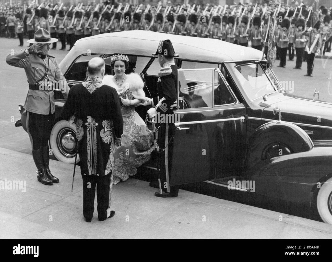 Queen allights de car at Parliament -- vêtu de vêtements de splendeur à couper le souffle la reine Elizabeth est accueillie par de hauts fonctionnaires alors qu'elle marche d'une voiture avant la maison du Parlement Ottawa, le 19th mai. Leurs Majestés ont été officiellement présentés aux députés. 19 juin 1939. (Photo par Acme photo). Banque D'Images