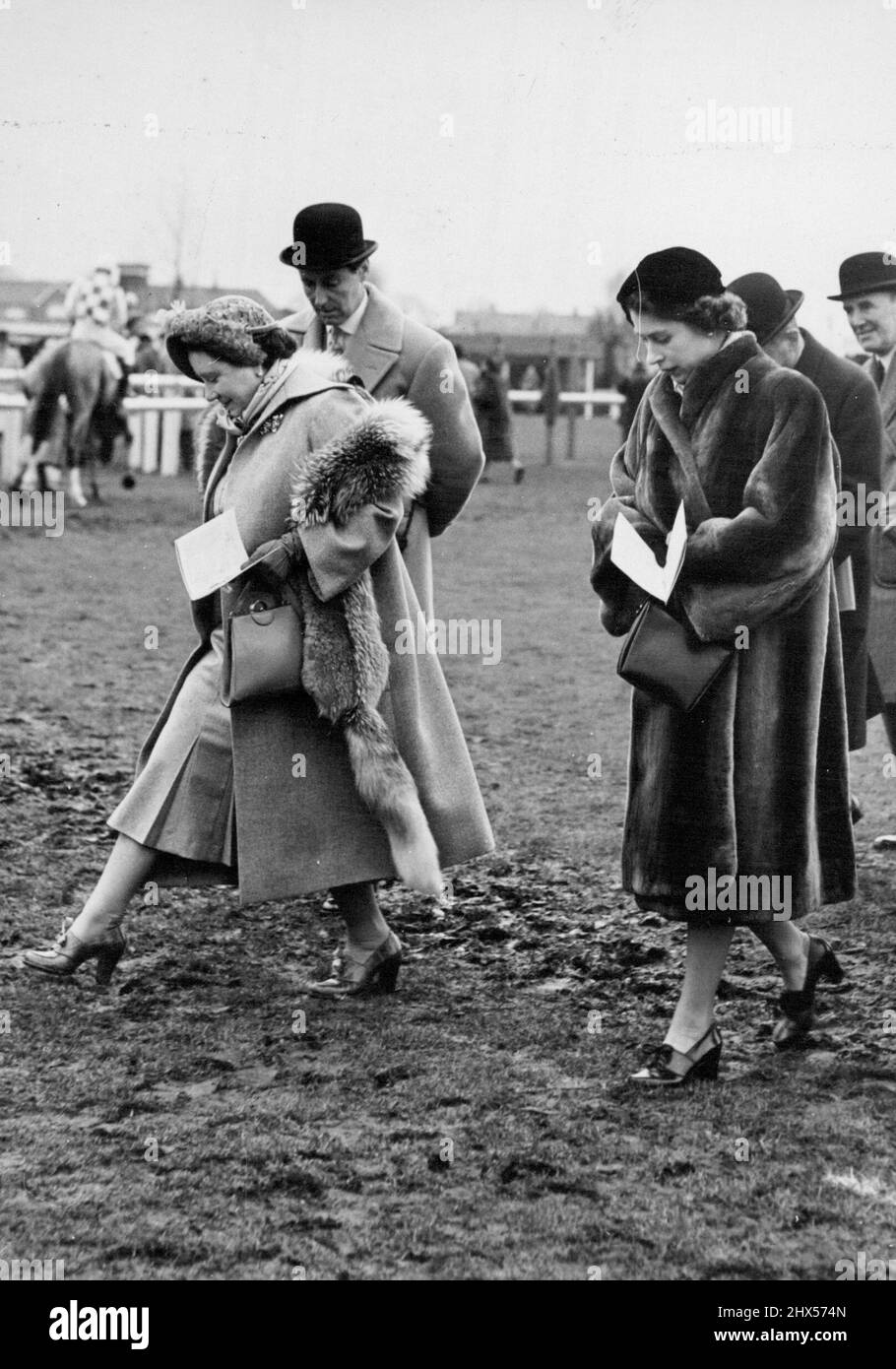 La Reine et la princesse Elizabeth à Hurst Party races - HM la Reine marche soigneusement sur le terrain boueux, suivie par la princesse Elizabeth alors qu'ils et leur partie traversent le parcours, à Hurst Park. La Reine a pris l'avion aujourd'hui de Sandringham pour regarder son cheval, Devon Looh, courir au parc Hurst. Elle y a été rejointe par la princesse Elizabeth qui a conduit de Clarence House. 17 janvier 1952. (Photo de Fox photos). Banque D'Images