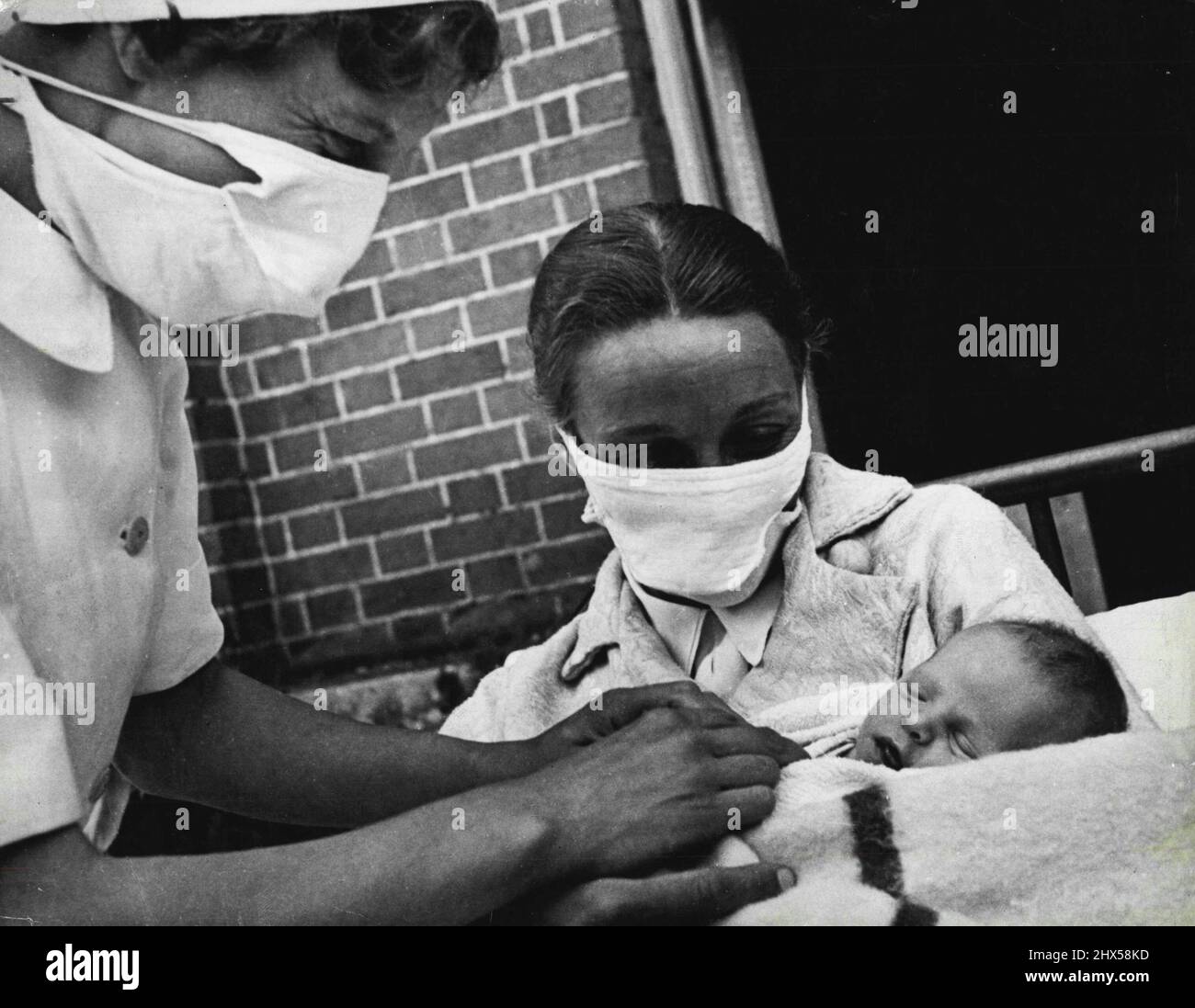 Mansion devient maison de maternité mère et les infirmières portent un masque de protection chaque fois que le bébé est manipulé dans le stade précoce. Les très jeunes sont des proies faciles pour les germes. 19 septembre 1951. (Photo par British Official Photograph). Banque D'Images