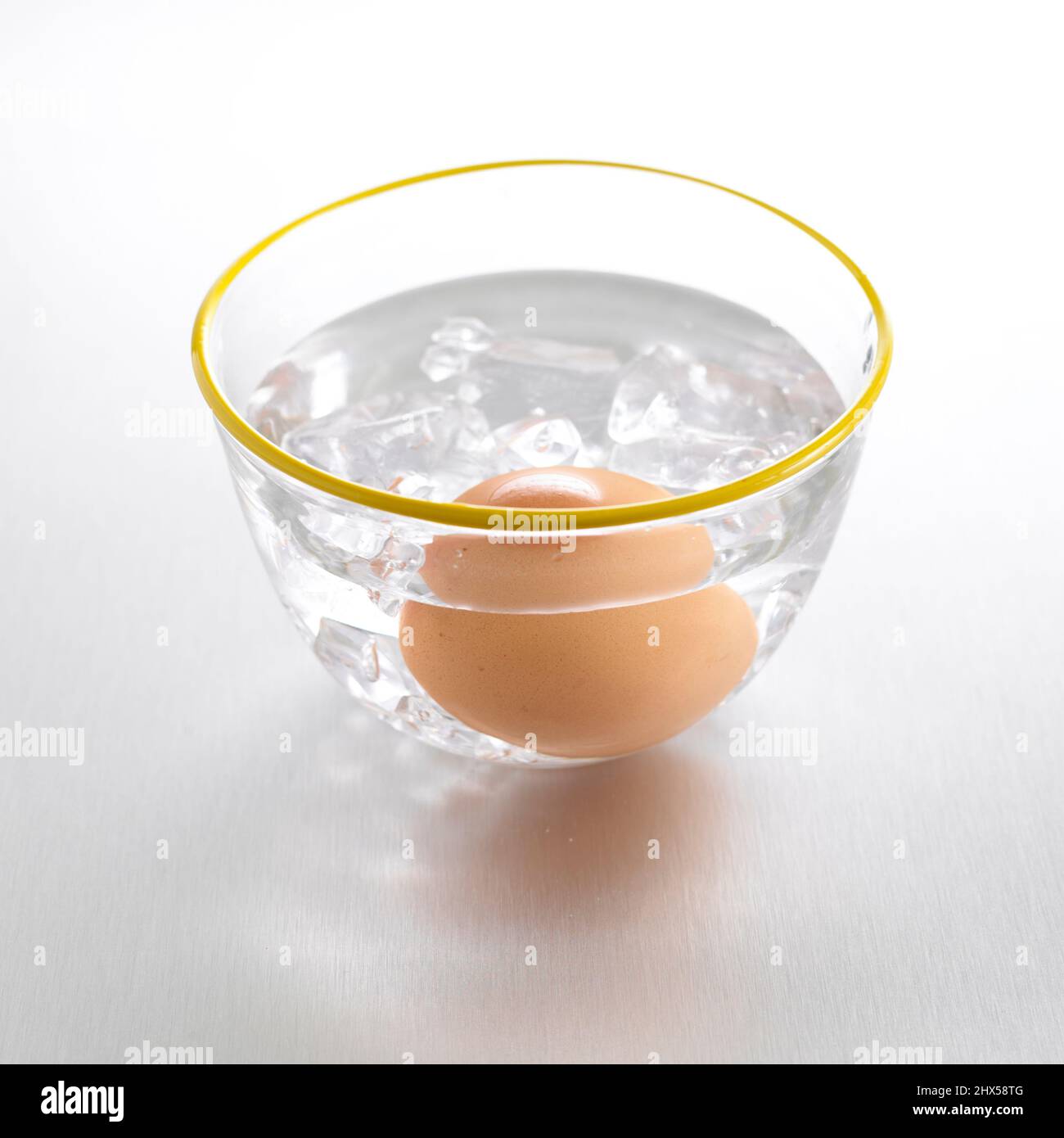 Refroidir l'œuf dur dans un bol d'eau et de glaçons froids Banque D'Images