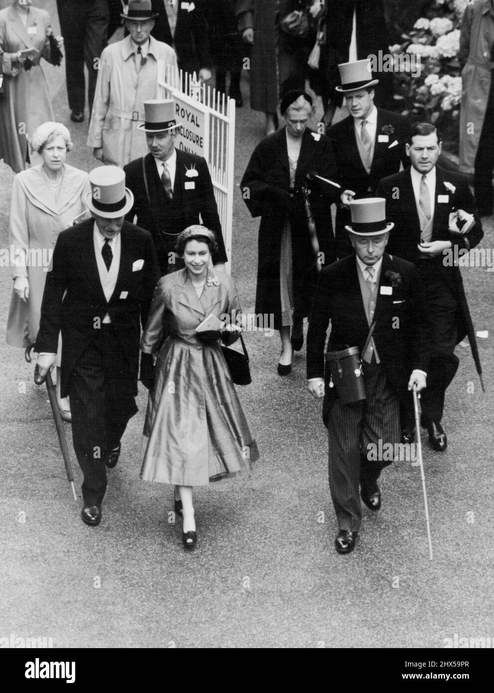 La Reine remporte la coupe de chasse à Ascot -- la Reine souriante qui marche jusqu'à l'enceinte de UnSaddling après que son cheval ait gagné la grande course de la journée à Ascot. Sur la droite se trouve le duc de Norfolk et derrière la reine on peut voir la princesse royale. Au deuxième jour de la rencontre royale d'Ascot, la grande course de la journée, la coupe Royale de chasse, a été gagnée pour sa Majesté la Reine par son cheval 'Choirboy', monté par D. Smith. 17 juin 1953. (Photo de Fox photos). Banque D'Images