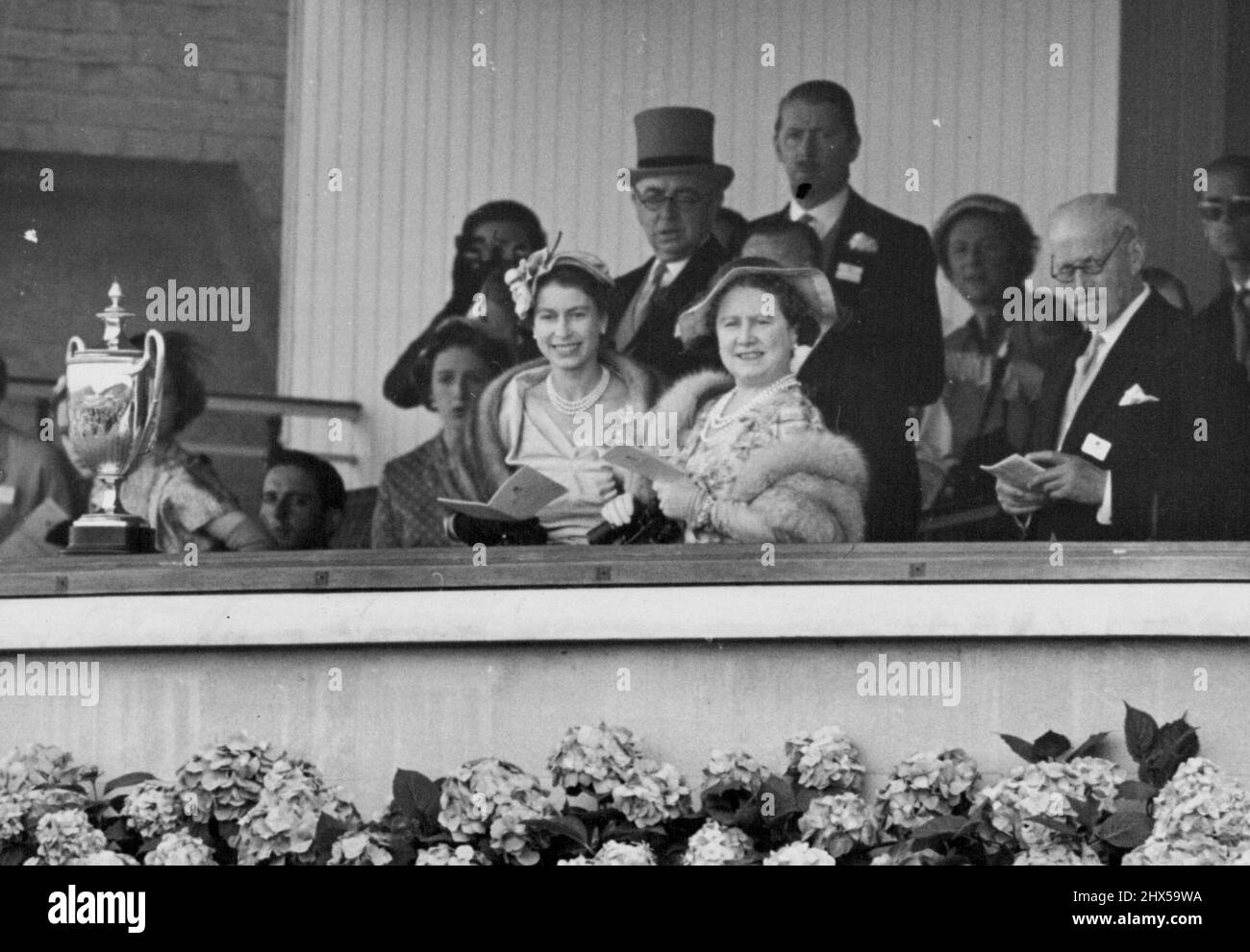 Famille royale à Ascot -- tous les sourires dans la boîte royale à Ascot cet après-midi sont H.M. la Reine et la Reine mère comme ils regardent la course. Plusieurs membres de la famille royale faisaient partie des grandes foules de spectateurs qui ont assisté à la course d'Ascot aujourd'hui, le premier jour de la rencontre royale d'Ascot. 15 juin 1954. (Photo de Fox photos). Banque D'Images