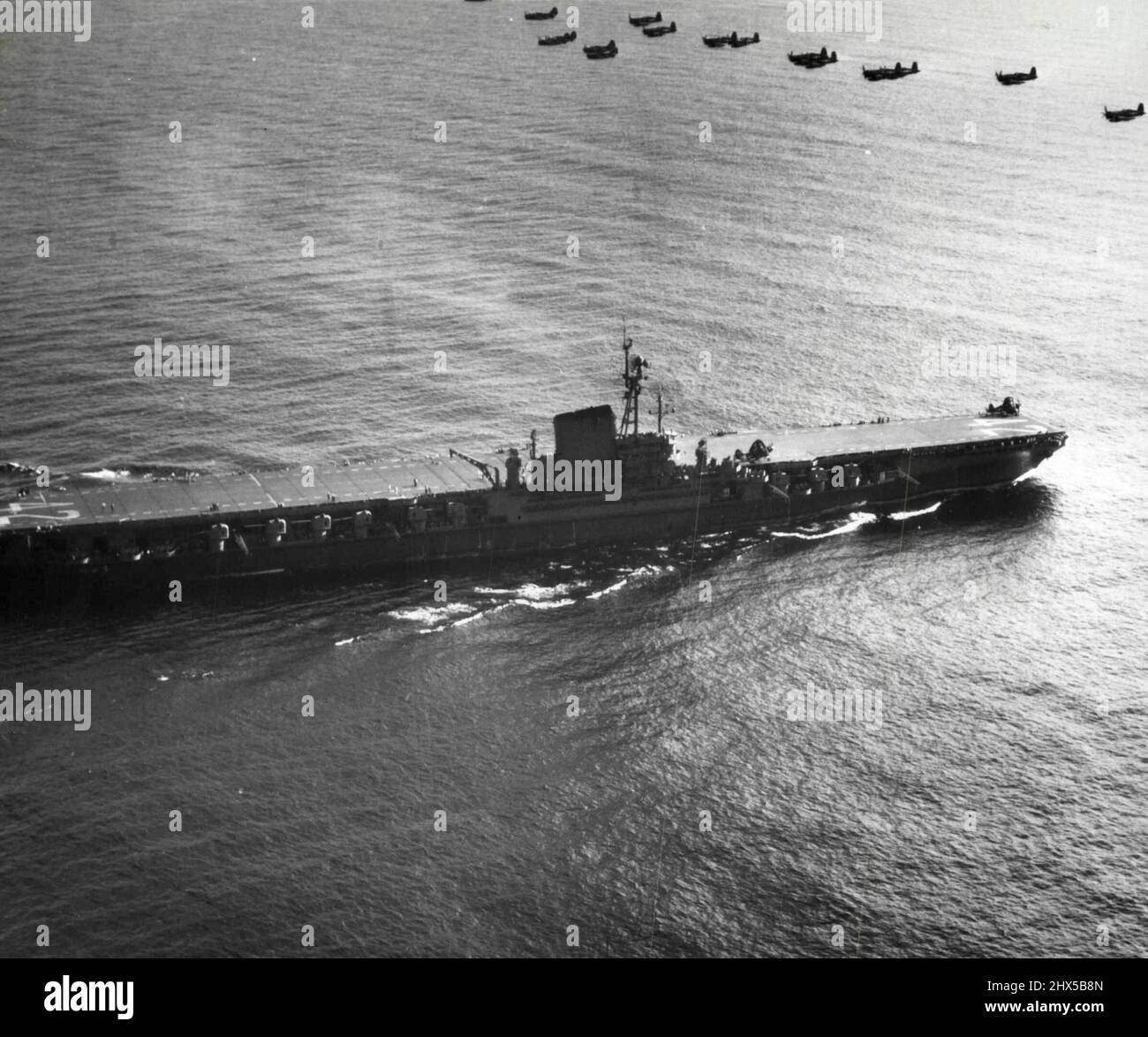 Les avions au-dessus du porte-avions Roosevelt - les bombardiers de plongée de la Marine et les avions de chasse se sont envolé le nouveau porte-avions de 45 000 tonnes Franklin D. Roosevelt après avoir pris son départ du pont de vol du navire lors de sa récente croisière en mer de Caridoan. Les membres de l'équipage marchent sur le pont de vol, Dare de tous à quelques avions. 27 janvier 1946. (Photo par photo de presse associée). Banque D'Images