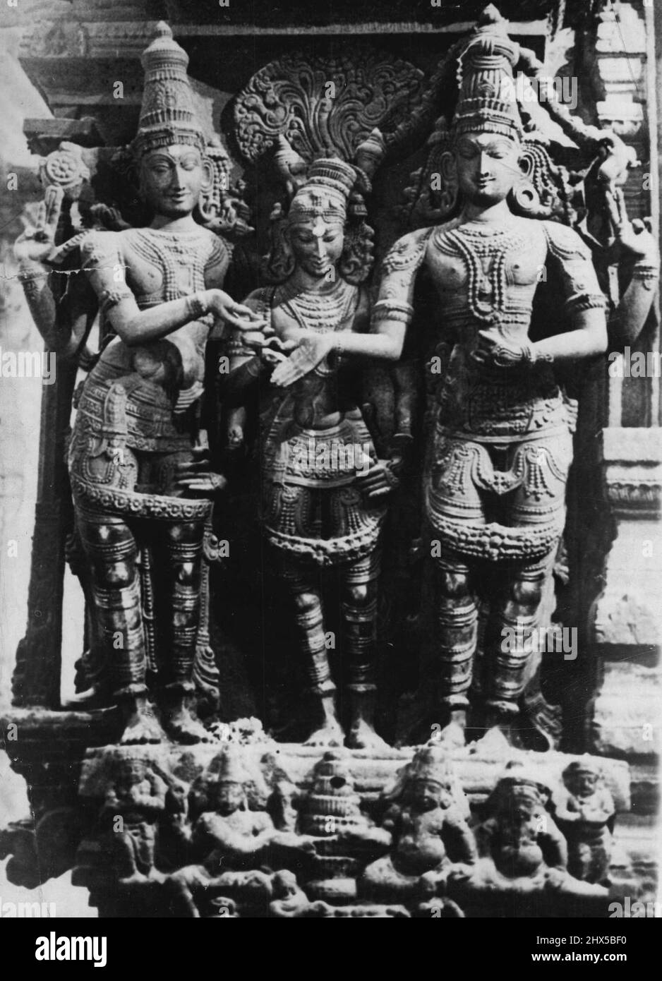 Splendeur de la sculpture indienne -- la splendeur de la sculpture indienne des temps anciens peut être trouvée dans beaucoup des temples indiens du Sud et d'autres bâtiments d'intérêt historique. Cette photo prise à l'intérieur du célèbre temple Minakshi de Madura illustre bien l'excellence de la sculpture indienne ancienne. Il dépeint le mariage de Sri Minakshi, avec le Dieu Parameswara Vishnu (à gauche) le deuxième membre de la sainte trinité donne la mariée, et Brahma conduit les rituels religieux. 7 mai 1934. (Photo de Keystone). Banque D'Images