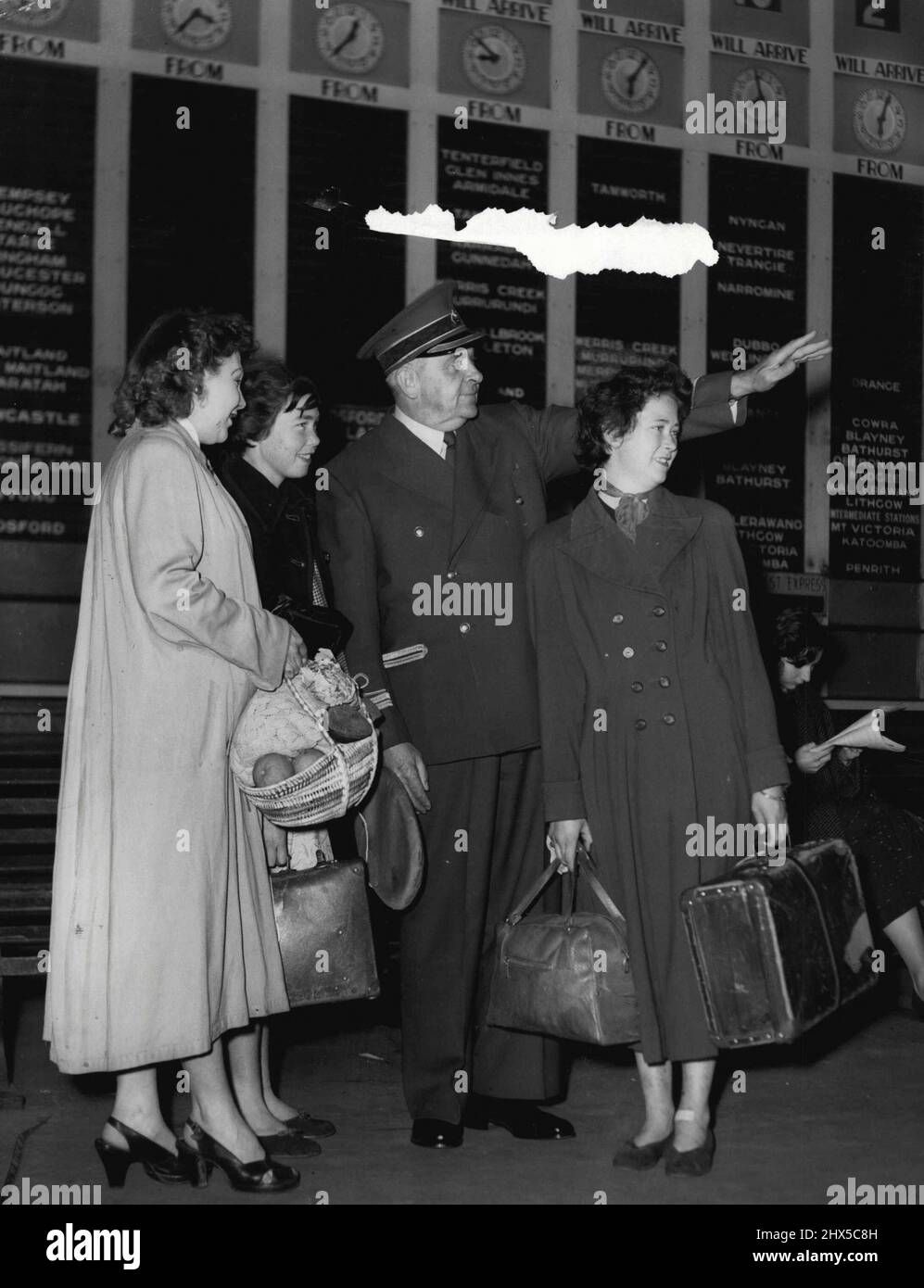 Man in Blue commence le service - le « Man in Blue », agent d'information M. A. W. Hanna, a fait sa première apparition à la gare centrale ce matin. Ici, il dirige les voyageurs vers la plate-forme Tamworth de gauche sont Mme A Eagleton de Newtown, a vu ses sœurs au loin après qu'ils l'avaient rendu visite, Mlle Joyce Picton, M. Hanna, Mlle Shirley Picton. Les filles de Picton viennent de Tamworth. 26 juillet 1955. (Photo de Ronald Leslie Stewart/Fairfax Media). Banque D'Images