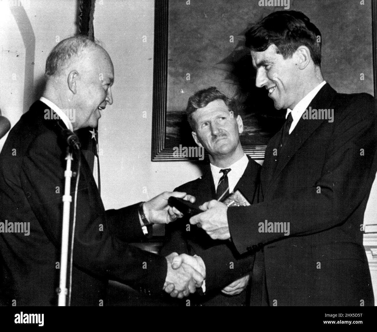Le président honore les alpinistes -- le président Eisenhower félicite Sir Edmund Hillary pour la remise de la médaille Hubbard de la National Geographic Society pour l'ascension au sommet du Mont. Everest fait par un parti britannique. Sir John Hunt, au centre, a également été honoré lors de la cérémonie à la Maison Blanche aujourd'hui. 11 février 1954. (Photo par AP Wirephoto). Banque D'Images