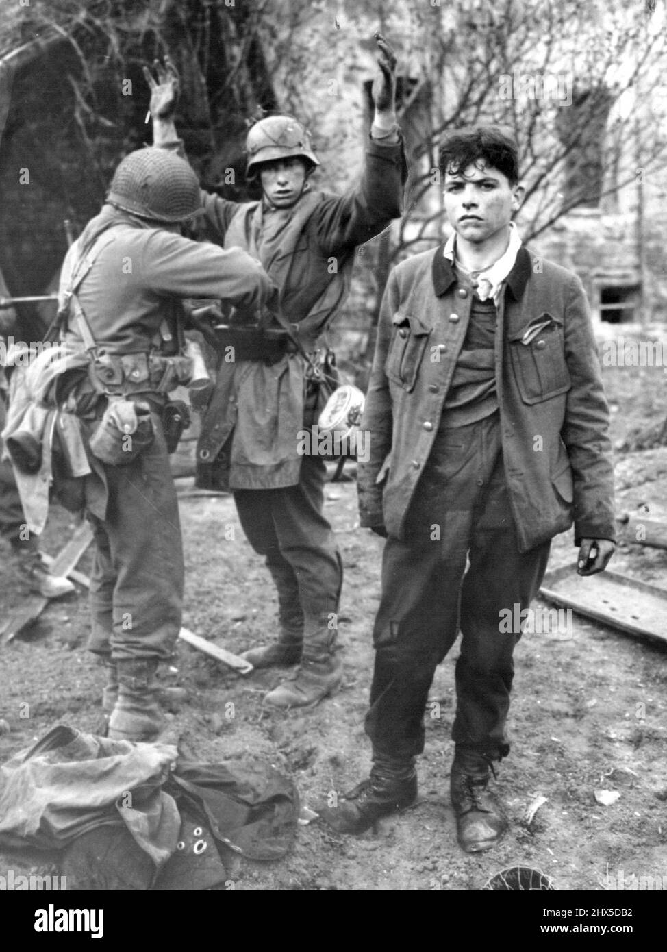 Sniper Vert capturé recherche un soldat américain recherche un sniper allemand capturé avec son camarade par Yanks de ***** . Un soldat américain cherche un sniper allemand capturé, avec un camarade jeune, par les troupes de la troisième Armée. Le sniper avait été blessé. 4 février 1945. (Photo par photo de presse associée). Banque D'Images