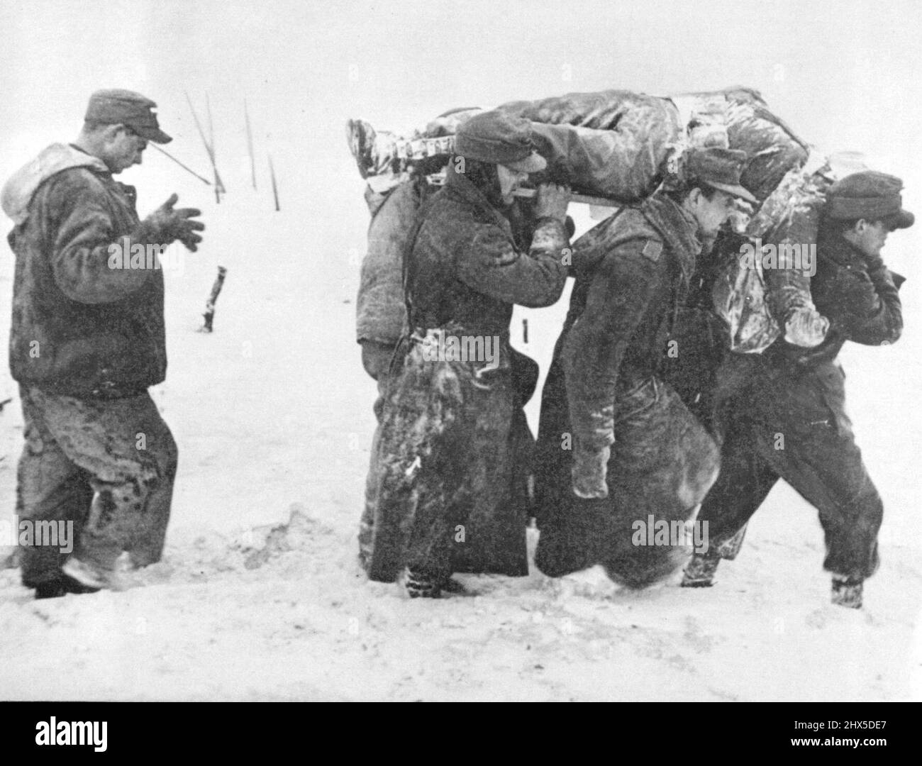 Les prisonniers allemands portent des morts américains six prisonniers allemands portent un soldat américain mort ***** Le terrain enneigé de la première armée des États-Unis se trouve devant une station d'aide aux champs. Le cortège funèbre est suivi d'un prisonnier allemand errant, avec les mains à moitié relevées. Photo réalisée par le photographe de la vie George Silk, sur attribuer-viande avec la piscine d'images fixes en temps de guerre. 14 février 1945. (Photo par photo de presse associée). Banque D'Images