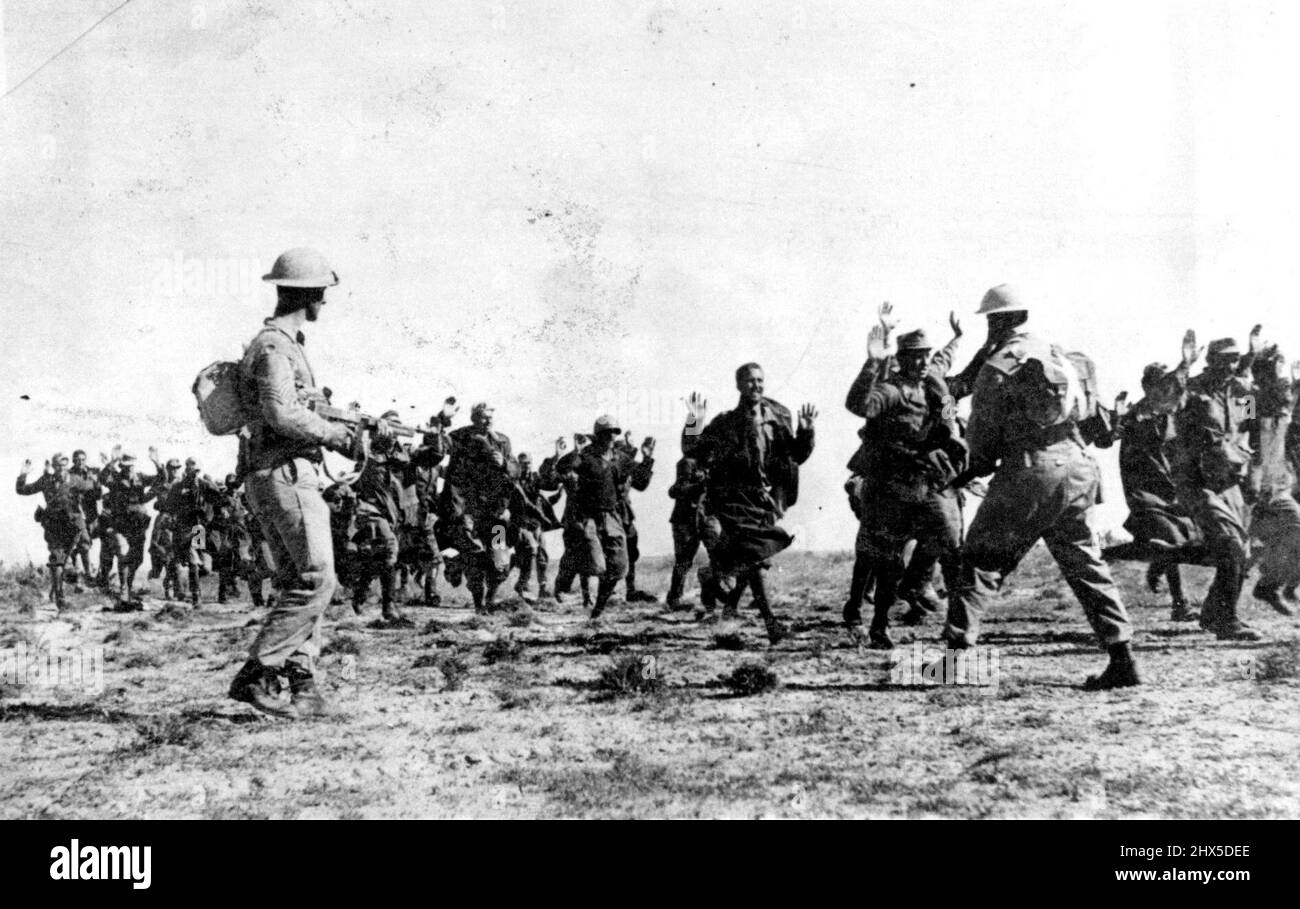 Les Italiens se rendent aux Britanniques en Tunisie. Leurs mains levées, un groupe de soldats italiens se rendent à Tommy-Gun portant la huitième armée pendant la conduite britannique vers le nord en Tunisie **** son groupe aurait été ***** 20 000 prisonniers capturés ***** Armée entre mars 20 et avril 12. 17 mai 1943. Banque D'Images