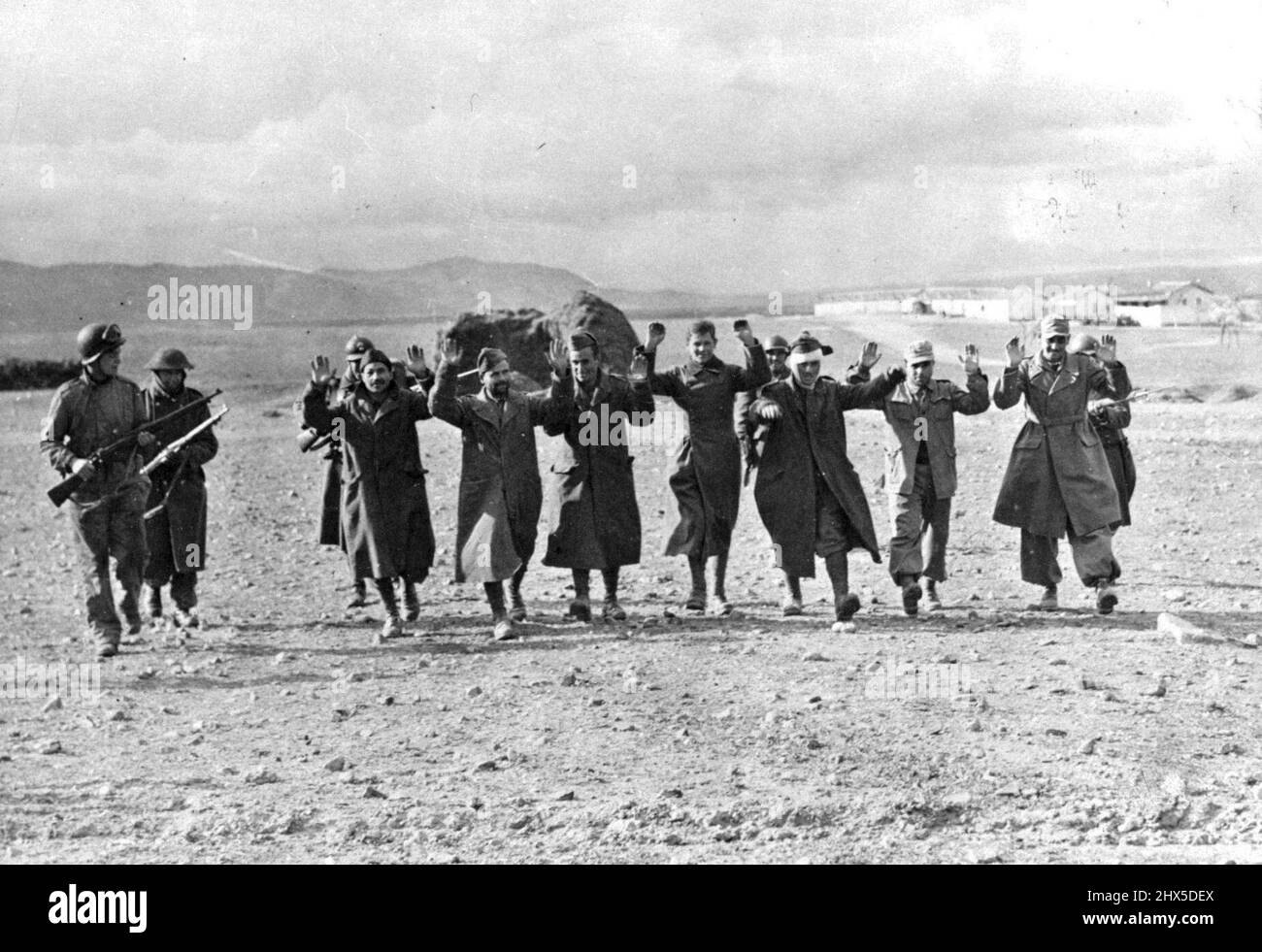 Prisonniers d'axe capturés en Tunisie ces prisonniers allemands et italiens ont été capturés lors de la contre-attaque américaine réussie au col de Kasserine, en Tunisie. Ils sont en train d'être marchés à l'arrière par des soldats alliés. 1 janvier 1943. (Photo de l'Office of War information Picture des États-Unis). Banque D'Images