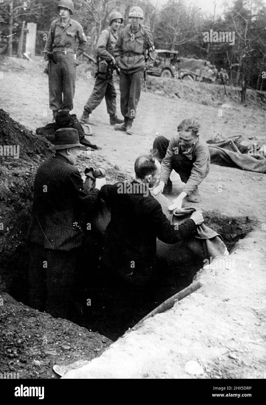 Ils ne laissent pas les Allemands toucher leurs morts -- cet homme et ce garçon polonais, ne permettrait pas aux Allemands de toucher leurs morts, et insistaient pour les enterrer eux-mêmes, après l'occupation de ***** Allemand, quand le ***** Gouvernement, agent, major David Paulette de Farmville, ***** commandé le ***** De la ville de rassembler environ 600 hommes pour creuser des tombes et enterrer les 2 500 prisonniers politiques dans le camp. L'homme a perdu sa mère et le garçon sa grand-mère dans ce camp de concentration nazi. 21 avril 1945. (Photo d'Acme) Banque D'Images