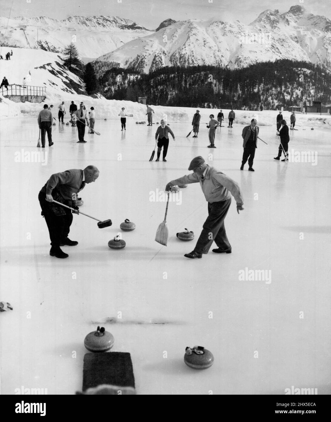 Villes du monde Saint-Moritz (cinquième de quatorze). Le pittoresque sport de curling est à voir à Saint-Moritz. Ici, au Kulm Hotel Curling Rink, les passionnés du jeu jouent avec les majestueuses Alpes qui s'élève en arrière-plan. Parmi les installations les plus impressionnantes du centre Aviemore, on trouve cette patinoire et cette piste de curling, d'une superficie de 20 000 pieds carrés. Les pierres de curling très polies pèsent plus de 40 lb 2 novembre 1955. (Photo de United Press). Banque D'Images