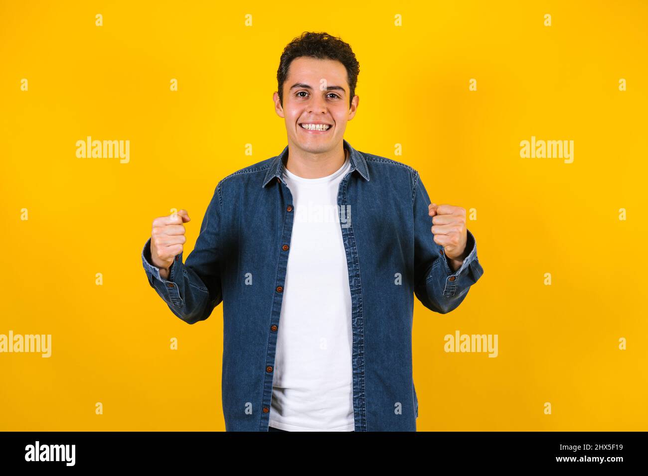 Portrait du jeune homme positif hispanique souriant sur fond jaune au Mexique en Amérique latine Banque D'Images Portrait du jeune homme positif hispanique souriant sur fond jaune au Mexique en Amérique latine Banque D'Images