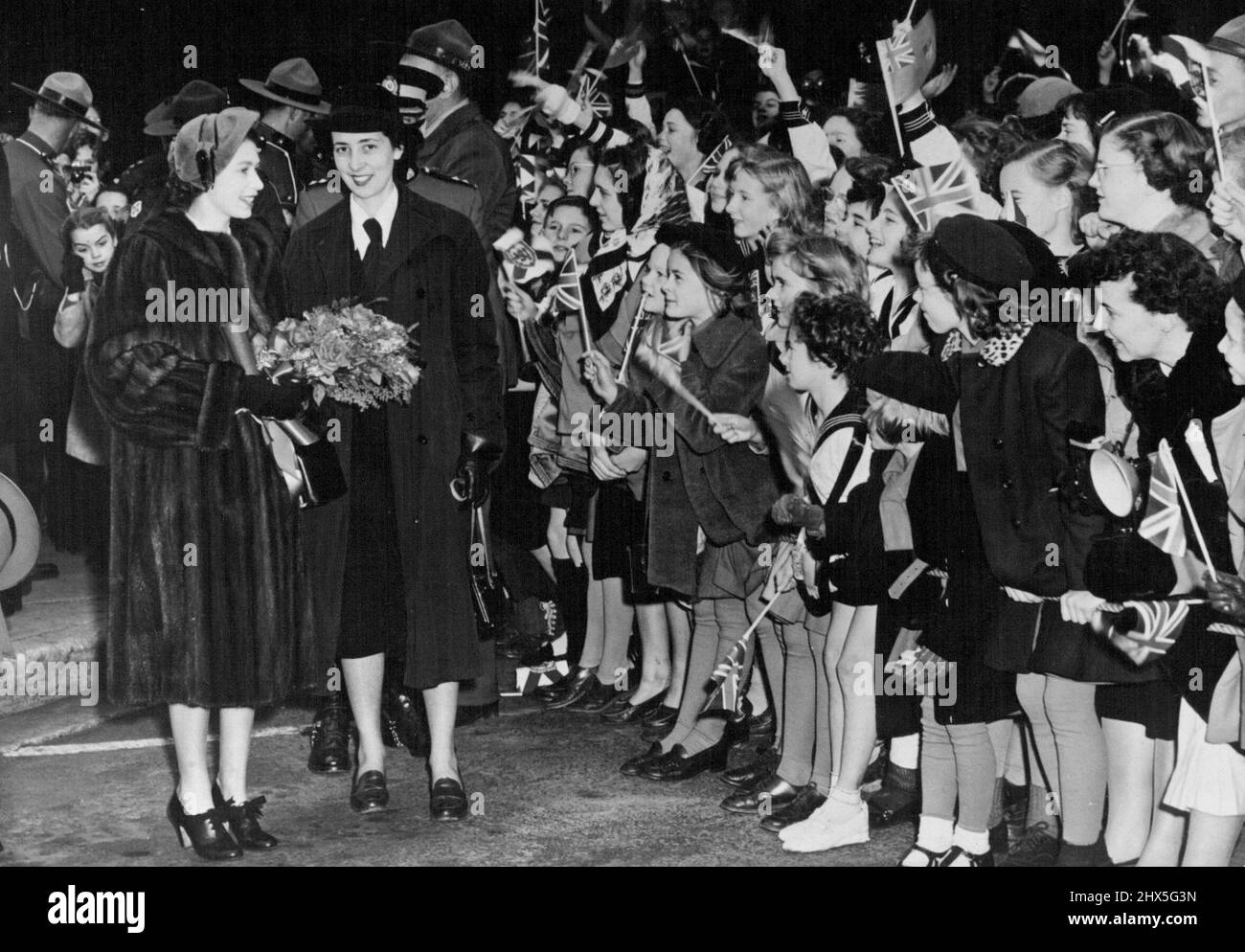 La princesse rencontre des écoliers de la Nouvelle-Écosse -- la princesse Elizabeth discute avec des écoliers lors d'un bref arrêt à Truro. Nouvelle-Écosse. Vers la fin de leur tournée canadienne, la princesse Elizabeth et le duc d'Édimbourg sont arrivés en Nouvelle-Écosse dans une tempête de vent et de pluie et ont visité plusieurs villes. 12 novembre 1951. (Photo de Fox photos). Banque D'Images