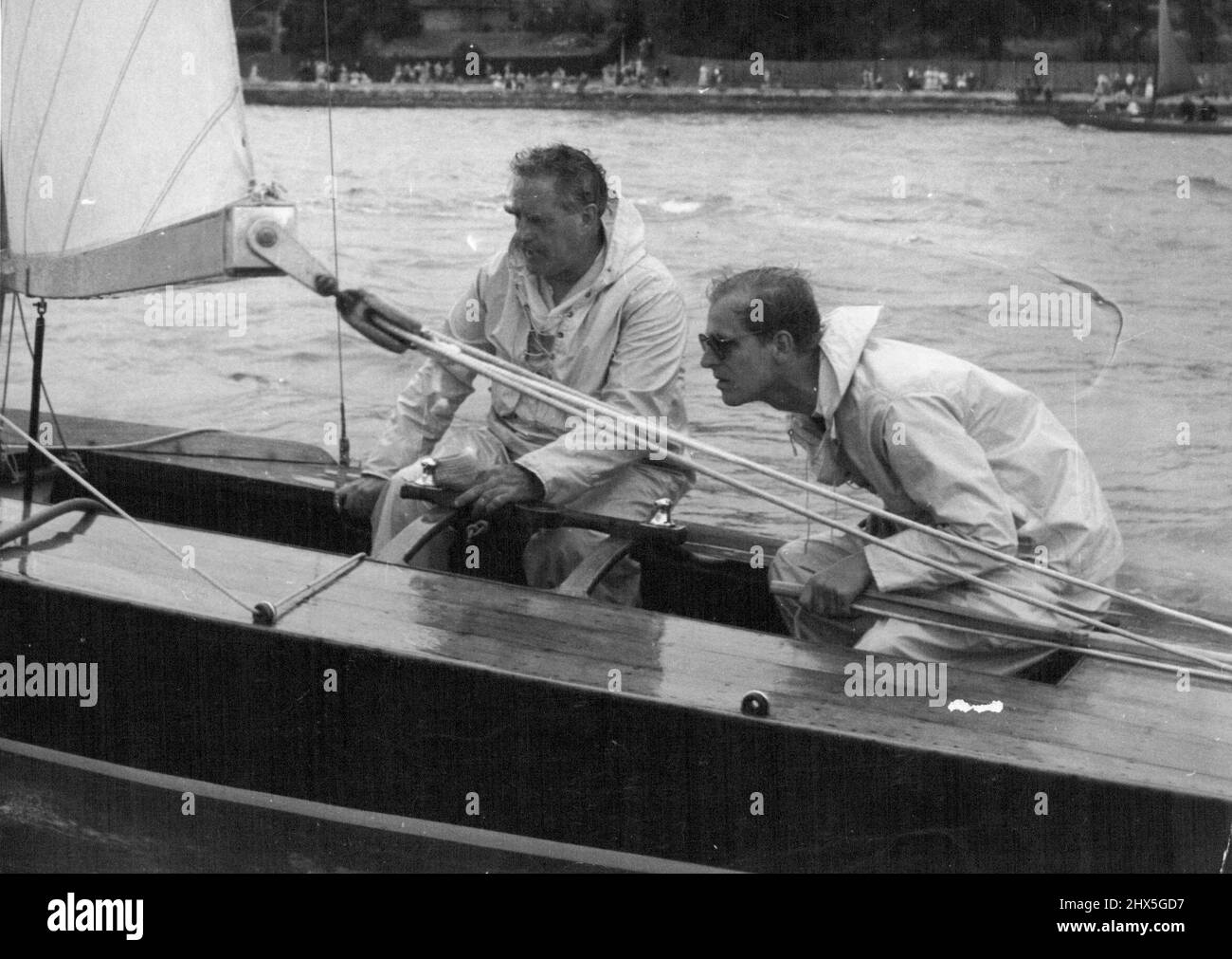 Le duc d'Édimbourg au timon de son yacht Coweslip pendant la course des quinze volants - pour 15ft. Bateaux - à Cowes I.O.W., hier. Lui et son associé, le concepteur de yacht UFFA Fox, étaient en deuxième position. Le duc s'est rendu directement sur la côte sud après avoir atterri à Londres au départ d'Helsinki. 6 août 1952. (Photo par Daily Mirror). Banque D'Images