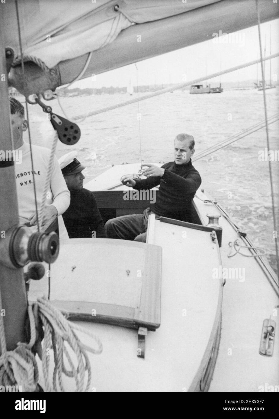 Le duc d'Édimbourg à bord du « Bluebottle » -- le « Bluebottle », un yacht de la classe Dragon (app.18 pieds de long) a été présenté à leurs Altesses Royales la princesse Elizabeth. Et le duc d'Édimbourg par le Club de voile de l'île. - Le duc a contesté sa première course sur le yacht quand il est entré dans le "Bluebottle" lors d'un récent événement de yachting à Cowes. Dans l'équipage de trois bateaux, le duc a agi comme troisième main. Le premier jour, 'Bluebottle' est arrivé troisième mais s'est disqualifié par le pâturage d'une bouée; le second, elle a fini 7th. La « Bluebottle » naviguant sur le Solent. Ensuite, le duc d'Édimbourg Banque D'Images