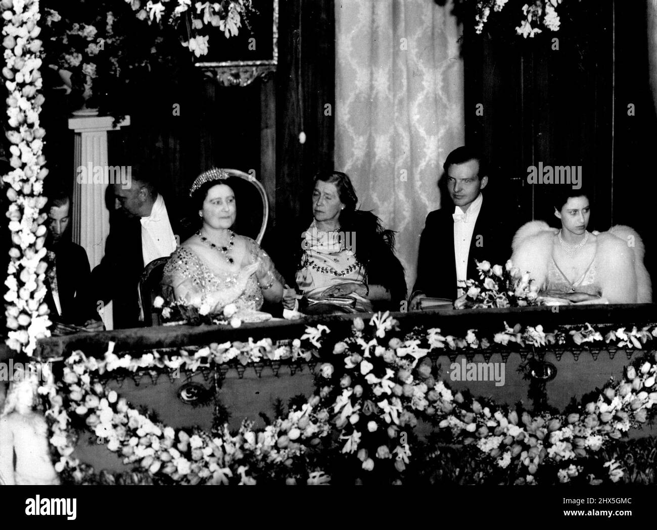 Queen and Princess Margaret at Covent Garden -- la Reine (premier plan à gauche) et la princesse Margaret (premier plan à droite) ont vu la représentation de 'Cindrella' à l'Opéra Royal, Covent Garden, Londres, en soirée le 25 avril. La performance a été à l'aide de Sadler's Wells Ballet Benevolent Fund. (De gauche à droite dans la boîte) Lord Porchester, Sir Eric Charles Mieville, la reine Elizabeth, Lady Delia Peel, le capitaine Lord Plunkett, les gardes irlandais, equerry temporaire au roi George VI et à la princesse Margaret. 5 mai 1949. (Photo par photo de presse associée). Banque D'Images