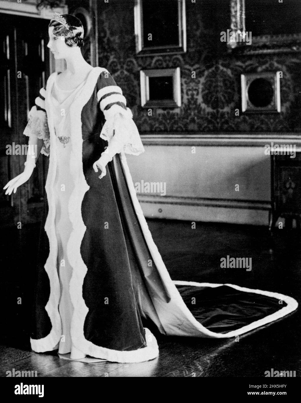 Robe de couronnement de Peeress nos photos montrent une robe de couronnement qui sera portée par une Viscountesse. Le Kirtle et le train sont en velours cramoisi avec des bords bordés de donneur (hermine). Il a été photographié à la maison Norfolk aujourd'hui, le 10 novembre. La finition en dentelle faite à la main des manches peut être portée en option. 30 novembre 1936. Banque D'Images