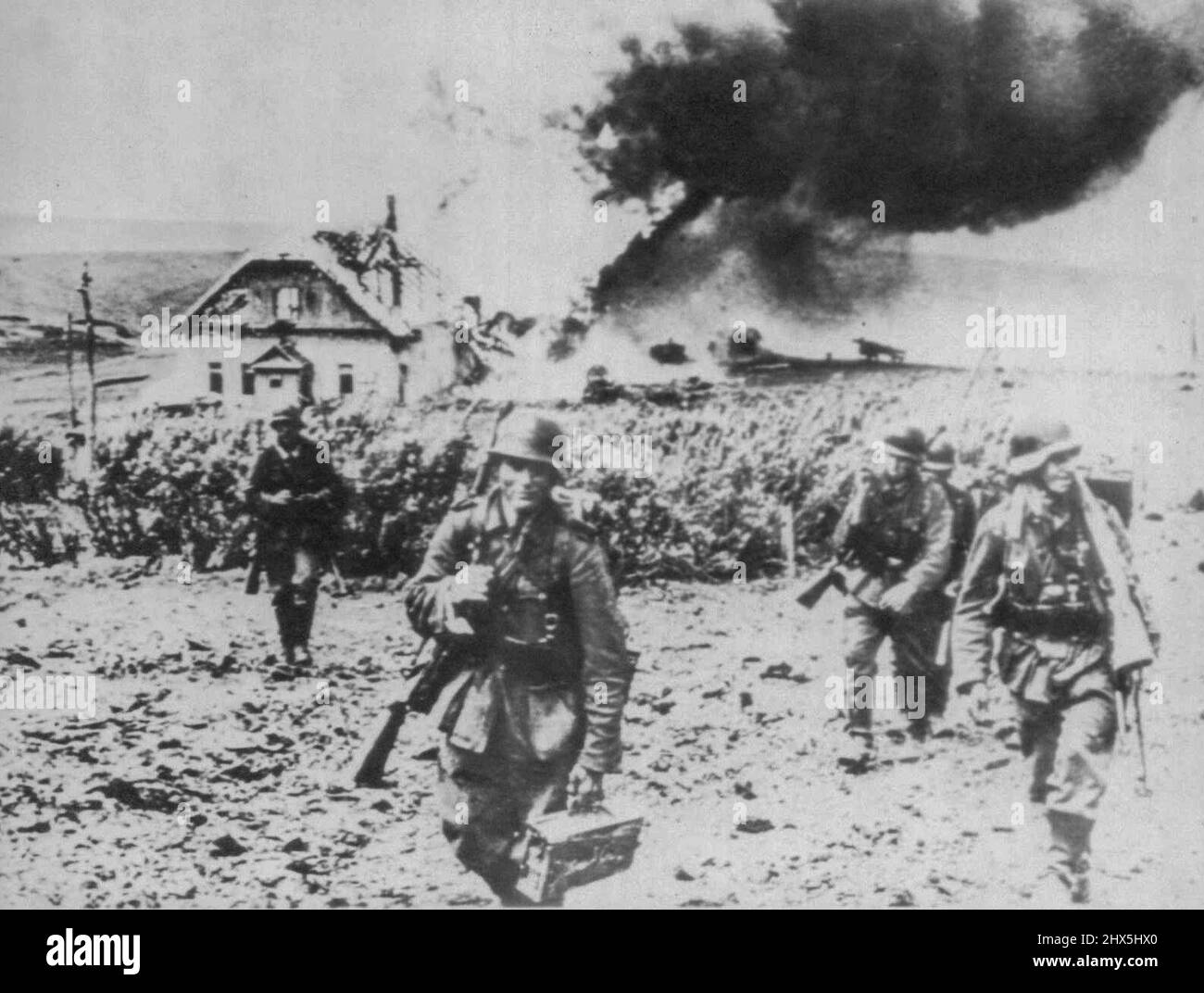 Les Allemands avancent dans le combat de Kharkov -- Un groupe de troupes allemandes poussent au-delà d'une ferme en feu à un point sur le front de Kharkov. Selon la légende allemande sur cette photo qui a atteint les États-Unis par le Portugal neutre. 17 juillet 1942. (Photo par AP Wirephoto). Banque D'Images