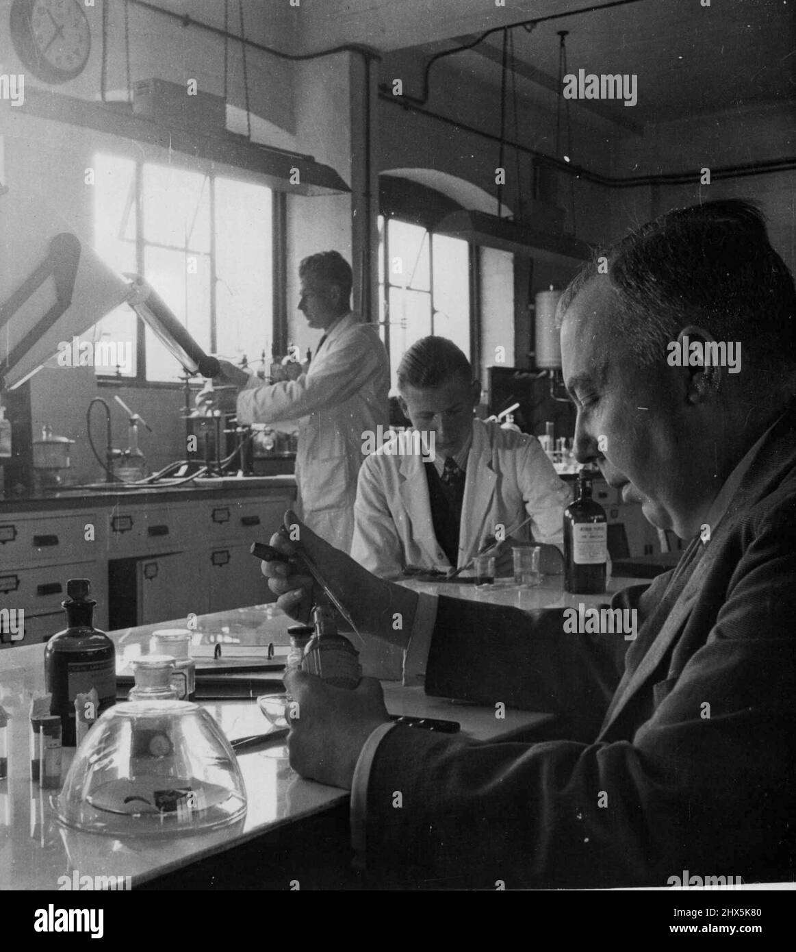 La science du côté de la justice -- Une enquête sur le poison se poursuit dans le laboratoire chimique du Laboratoire des sciences judiciaires de Bristol. Le directeur Parkes fait un test de présence de morphine dans les organes d'un corps humain; la dernière étape d'une recherche compliquée. 29 décembre 1947. (Photo de Totopique Press). Banque D'Images