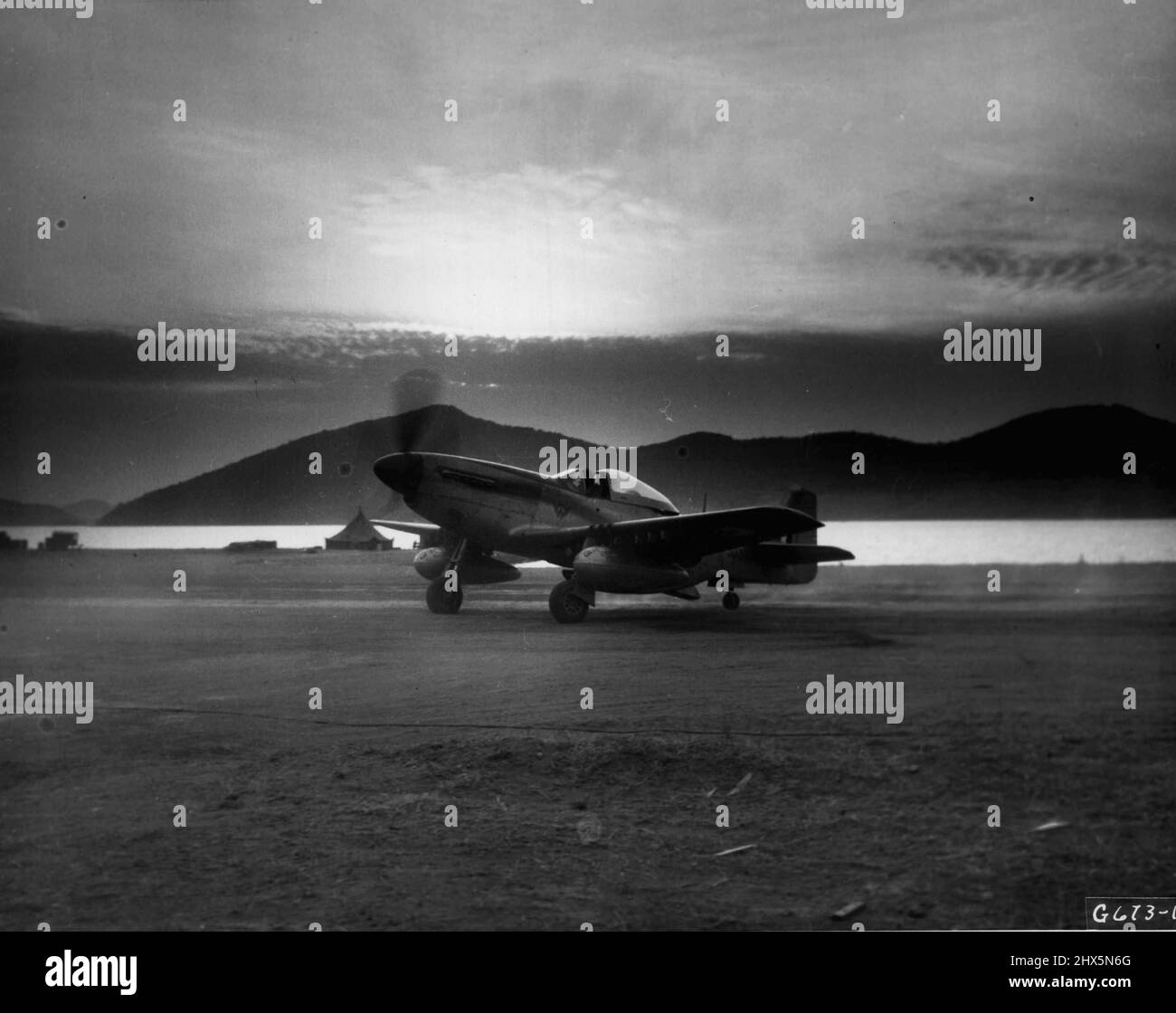 'By Dawn's Early Light' - lever du soleil sur les collines et l'eau de la Corée constitue un cadre pittoresque pour cette F-51 mustang de l'Armée de l'air sud-africaine, son pilote 'taxis' jusqu'à la fin de la piste pour un décollage à l'aube en soutien aux forces terrestres de l'ONU. Les Cheetahs sont les alliés bienvenus des forces aériennes américaines d'extrême-Orient dans le maintien de la suprématie aérienne en Corée. 19 mars 1951. (Photo de S.A. Air Force photo). Banque D'Images