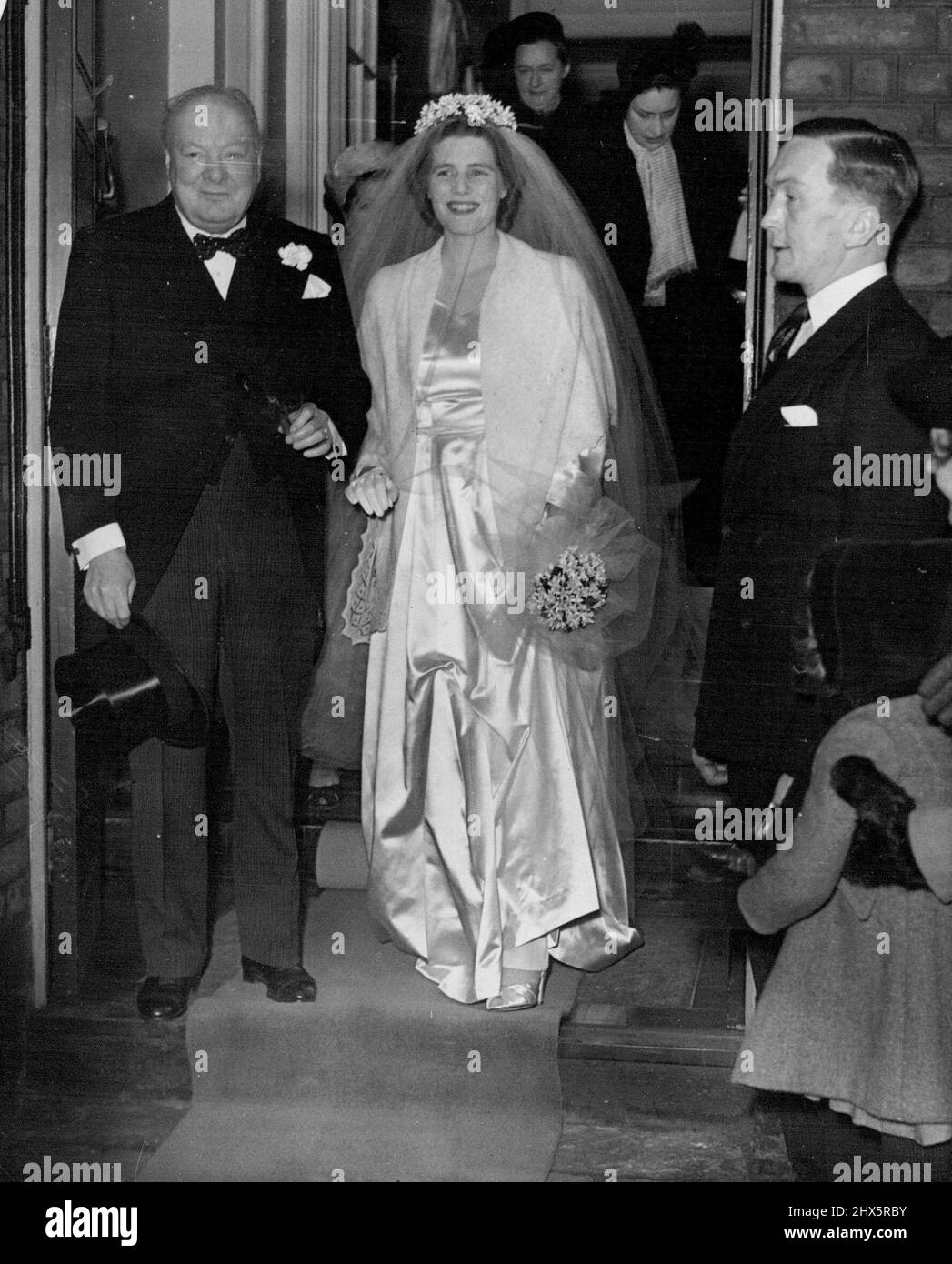 Le mariage de Mary Churchill -- M. Winston Churchill et sa fille, Mary, quittent leur maison à Hyde Park Gate pour St. Margaret's à jour, mardi. Mlle Mary Churchill, la plus jeune fille de M. Winston Churchill et Mme Churchill, de Chartwell, Westerham, Kent, a été mariée de jour en jour, Mardi, au capitaine Christopher Soames, les Coldstream Guards, à St. Margaret's Westminster. La mariée, qui a été donnée loin par son père, portait une robe de mariage classique de satin blanc de Slipper, la jupe pleine coupée un avec le train. Sa couronne de fleur d'oranger était assortie d'un bouquet de fleurs d'oranger. 11 février 1947. Banque D'Images
