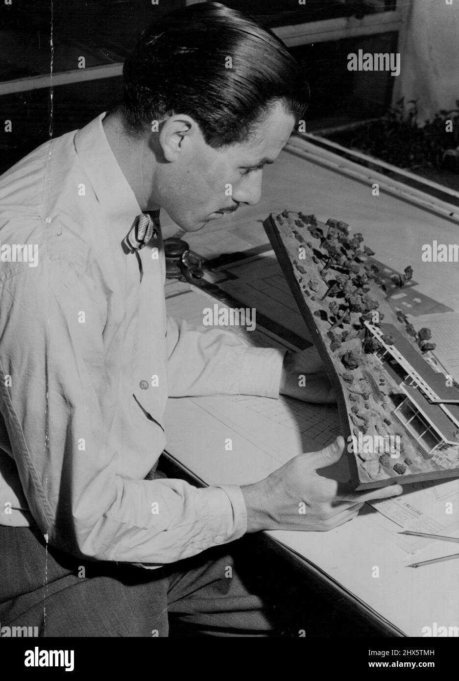 Douglas B. Snelling -- Snelling étudie un modèle de maison qu'il construit pour un homme d'affaires australien. La disposition est dédiée aux conditions climatiques de Sydney ***** . 10 mai 1950. Banque D'Images