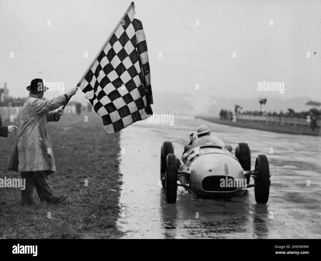 La nouvelle voiture de course britannique gagne deux fois -- 'IA a fait ça agin' Reg Parnell vagues comme il obtient le drapeau gagnant dans la coupe Goodwood. En Grande-Bretagne, la nouvelle voiture de course B.R.M. £2000 000 conduite par Reg Parnell, en pluie battante, a remporté les principaux événements de la rencontre intercontinentale de course automobile à Goodwood, Sussex, aujourd'hui samedi 30th septembre.) Une foule de a vu la voiture voler après le renfoncement suisse. Baron de-Grafenried dans le Woodcote ***** dont le tour le plus rapide était de 82,01 miles par heure et une vitesse moyenne de 78,5 mph TH Banque D'Images